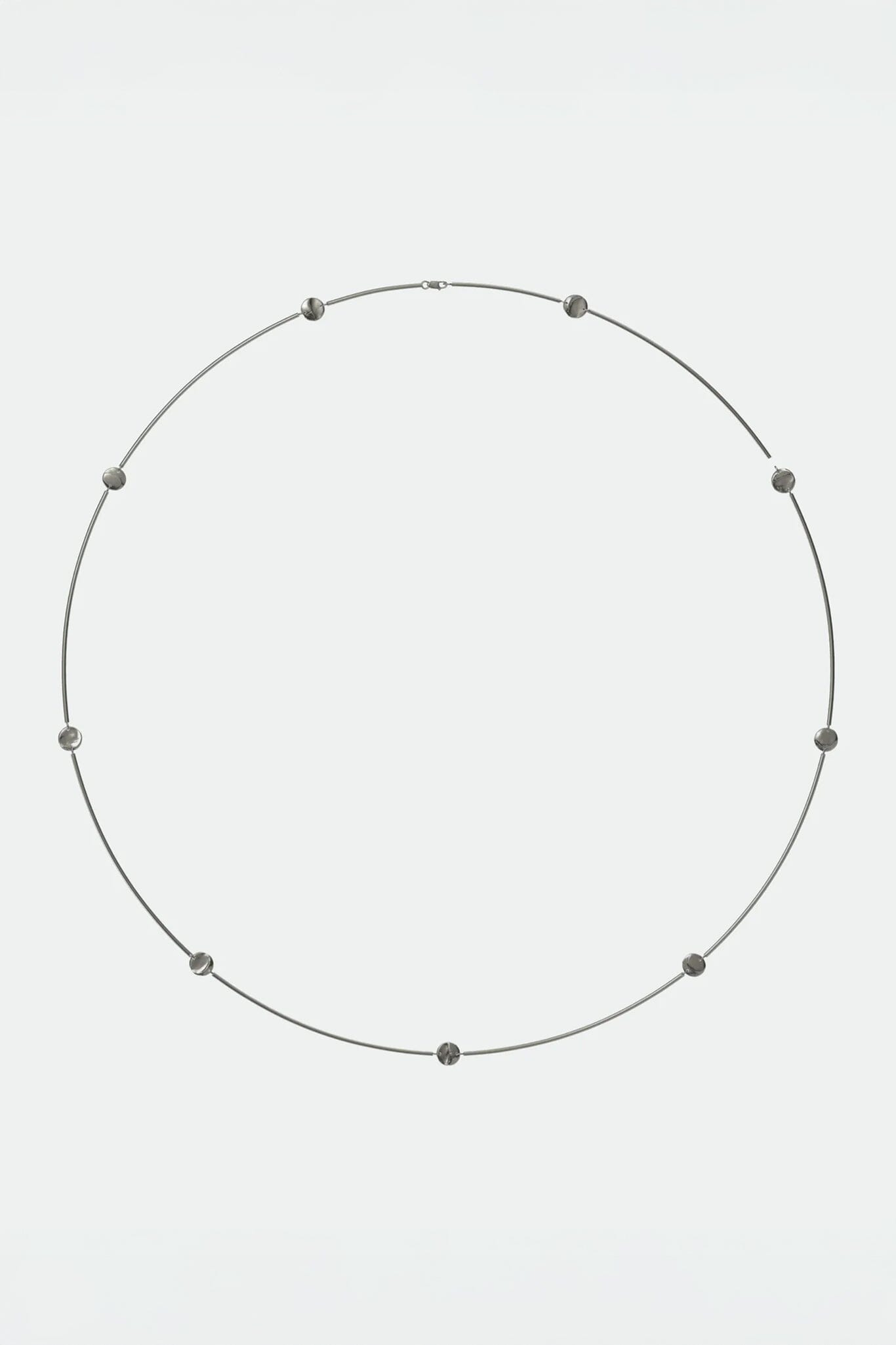 Necklace with small, flat coin beads on a light gray background