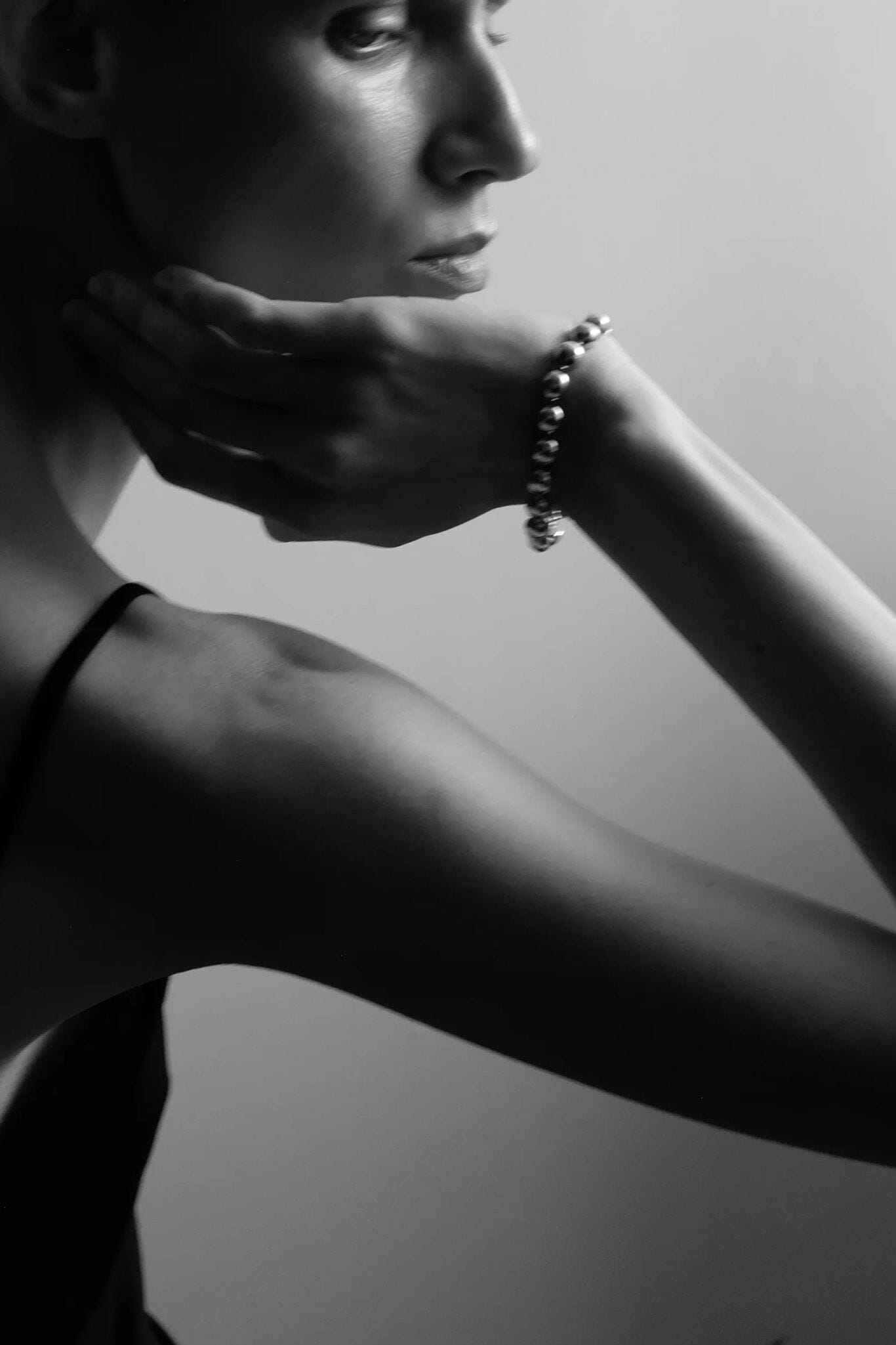 Black and white portrait of a woman with a silver dome bracelet
