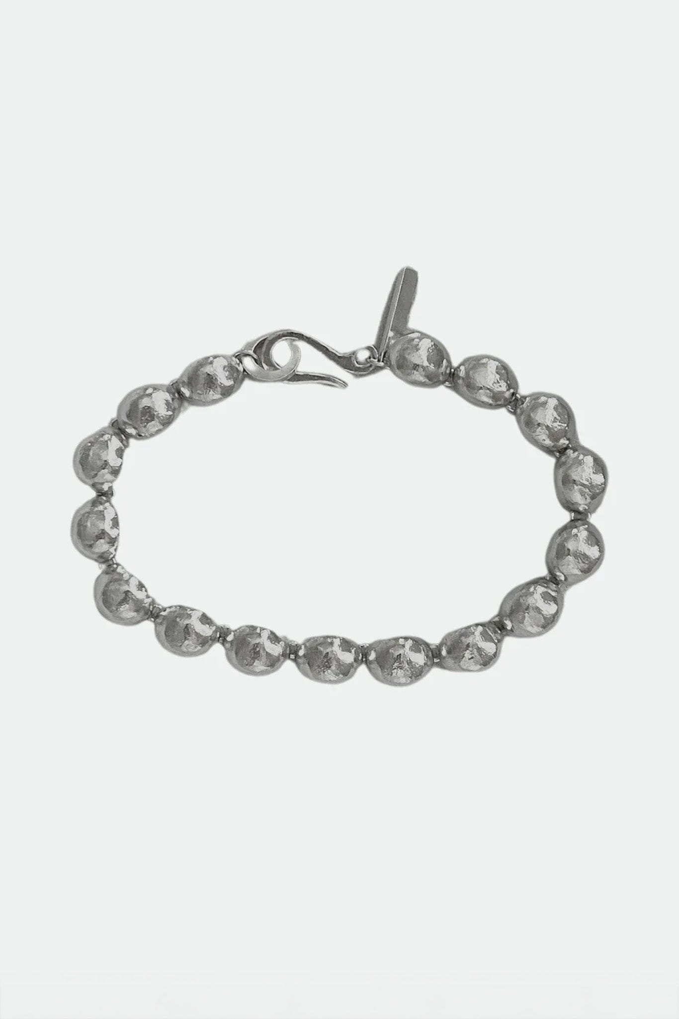 Silver bracelet with silver dome pendent beads on a white background
