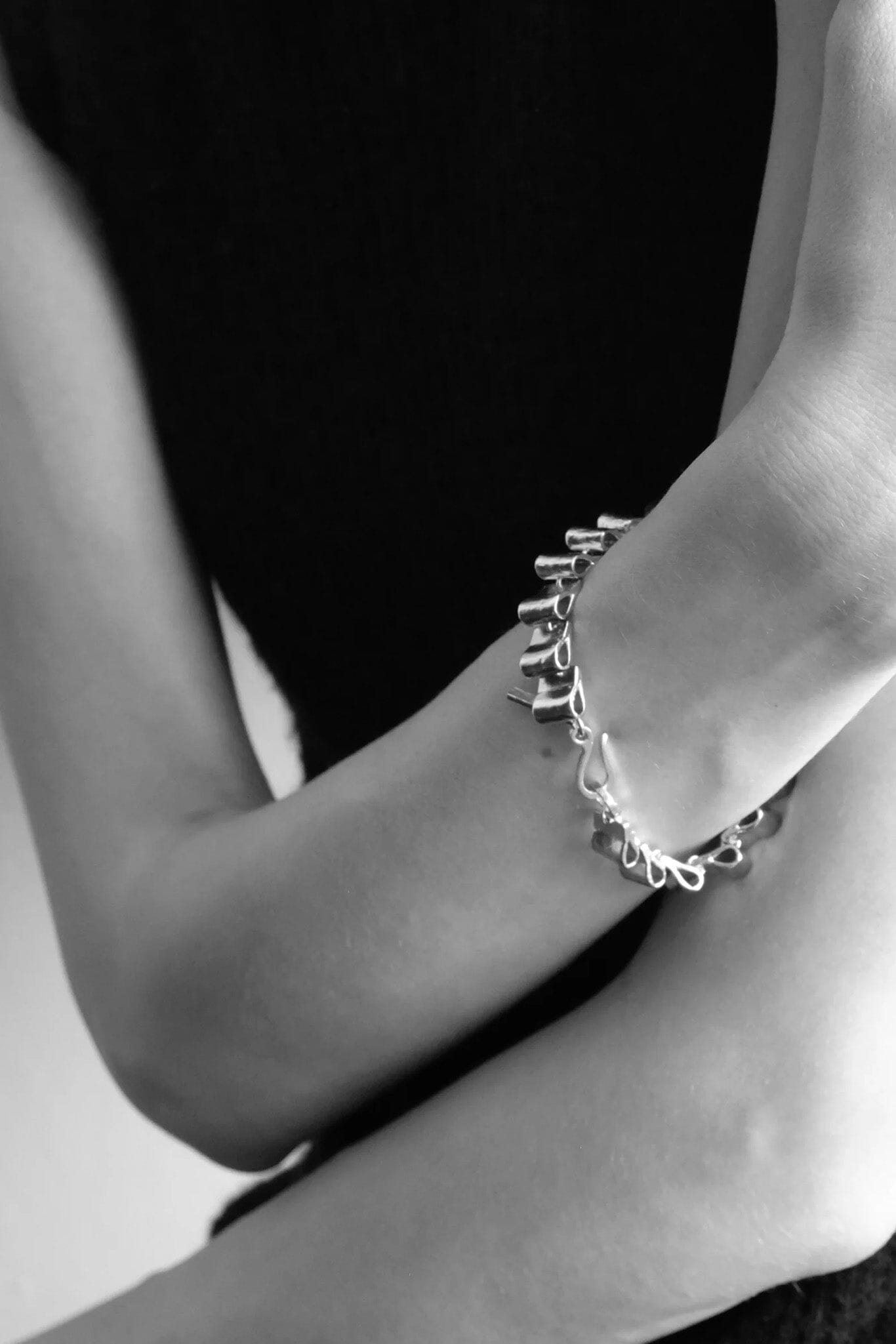 Close-up of a person's arm wearing a silver structural bracelet