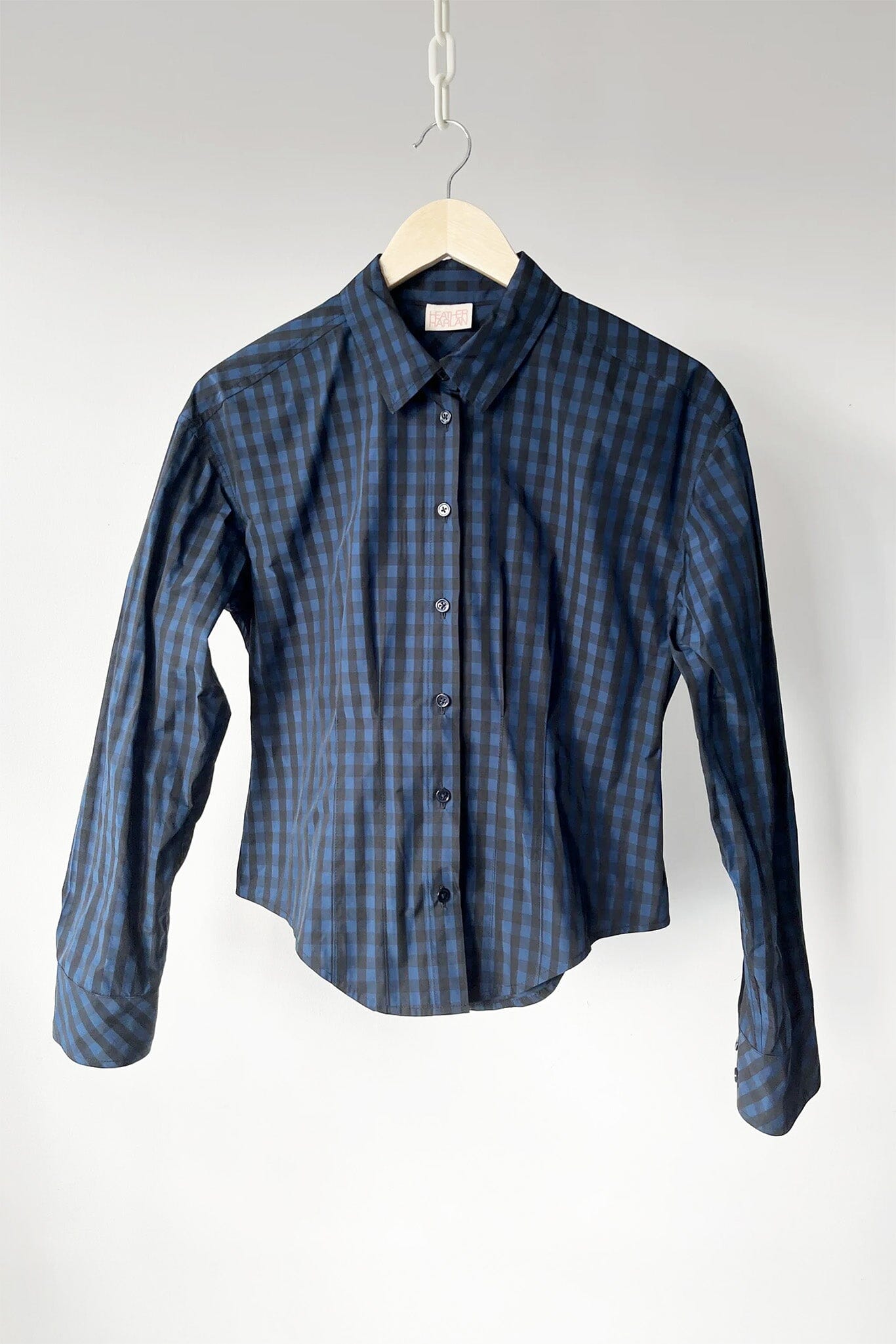Blue checkered shirt on a hanger against a white background