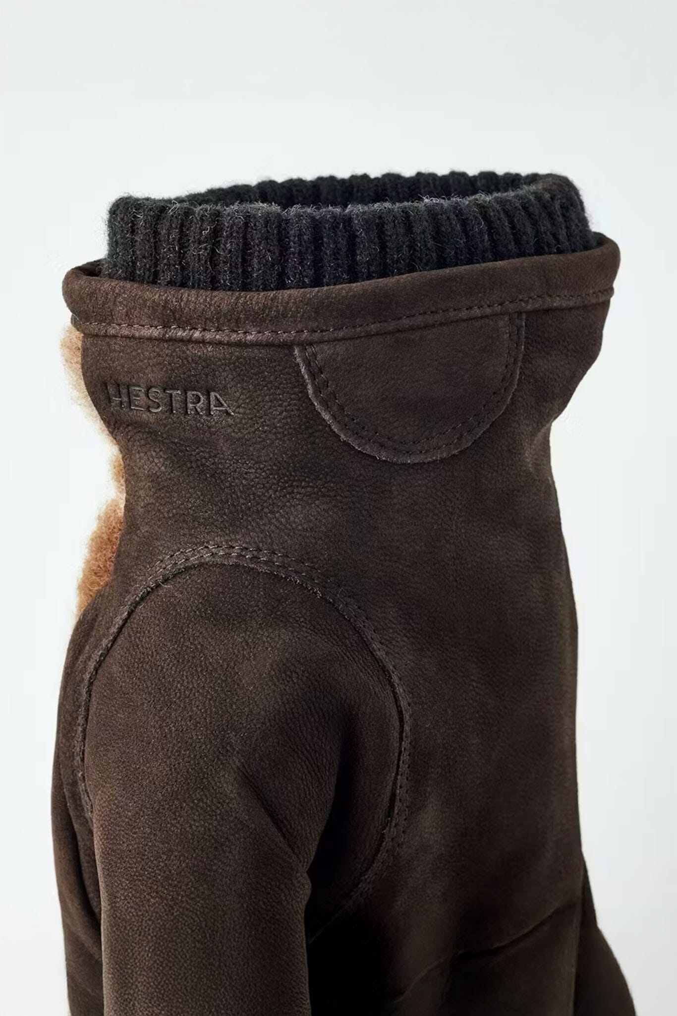 Brown leather and wool glove with black ribbed collar on a white background