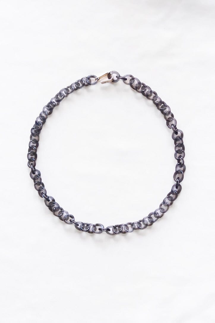 A gray glass small chain necklace with a sterling silver hook clasp, displayed against a white background.