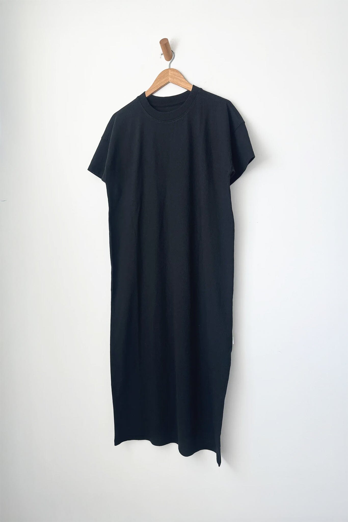 Black short sleeve long dress on a hanger against a white background