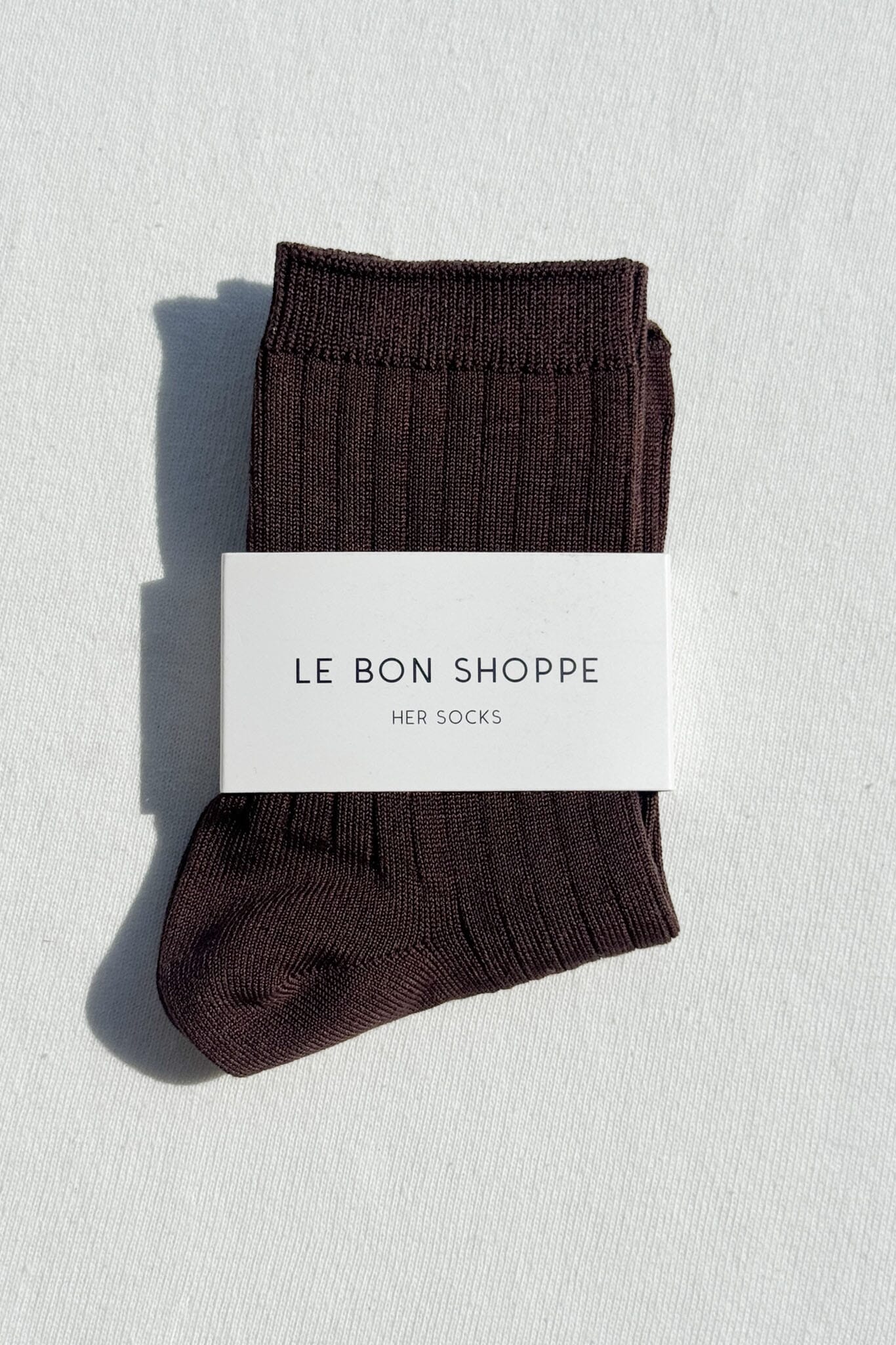 Pair of brown socks with a 'Le Bon Shoppe' label on a light gray background