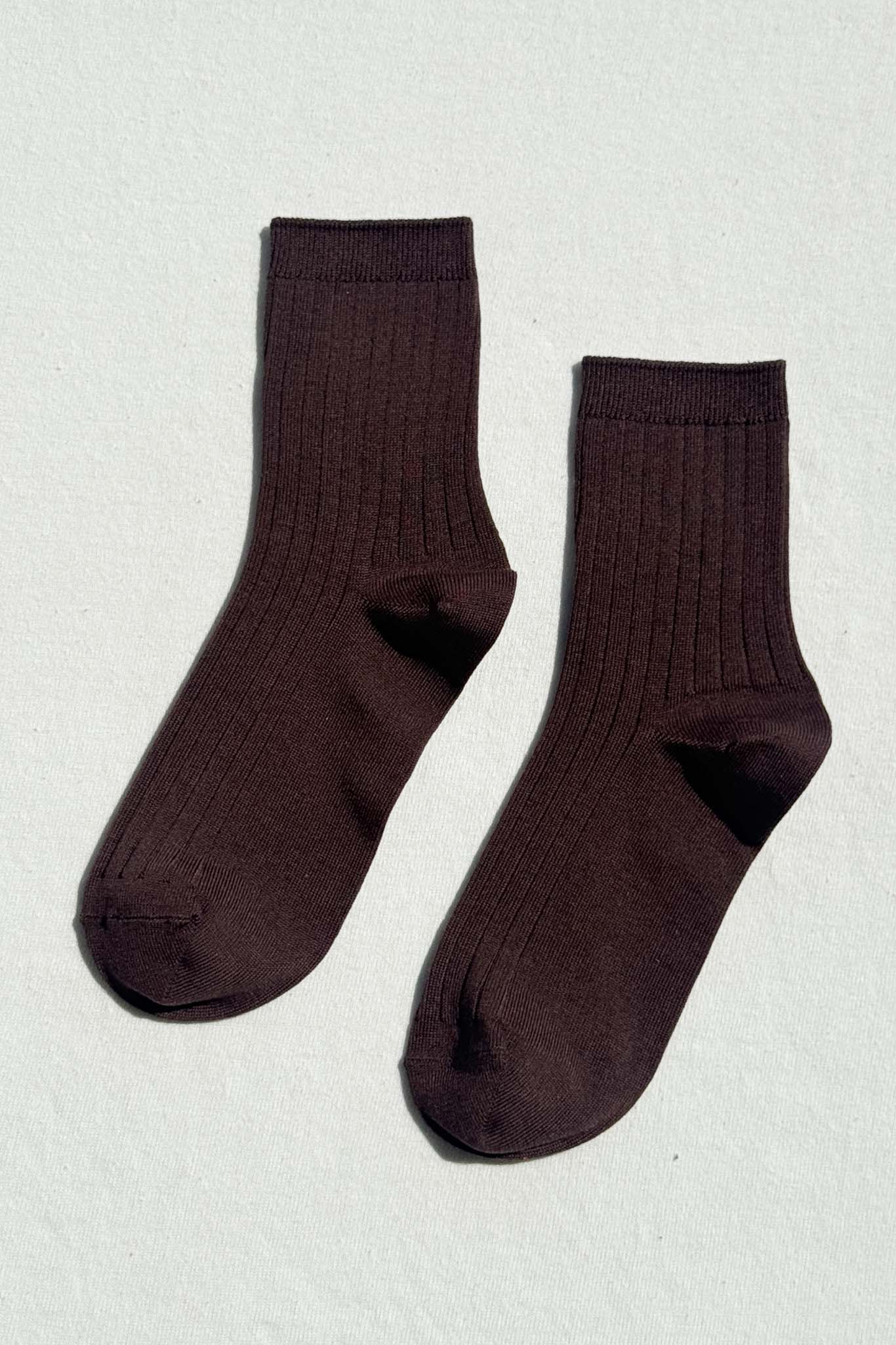 Pair of dark brown socks on a light gray background