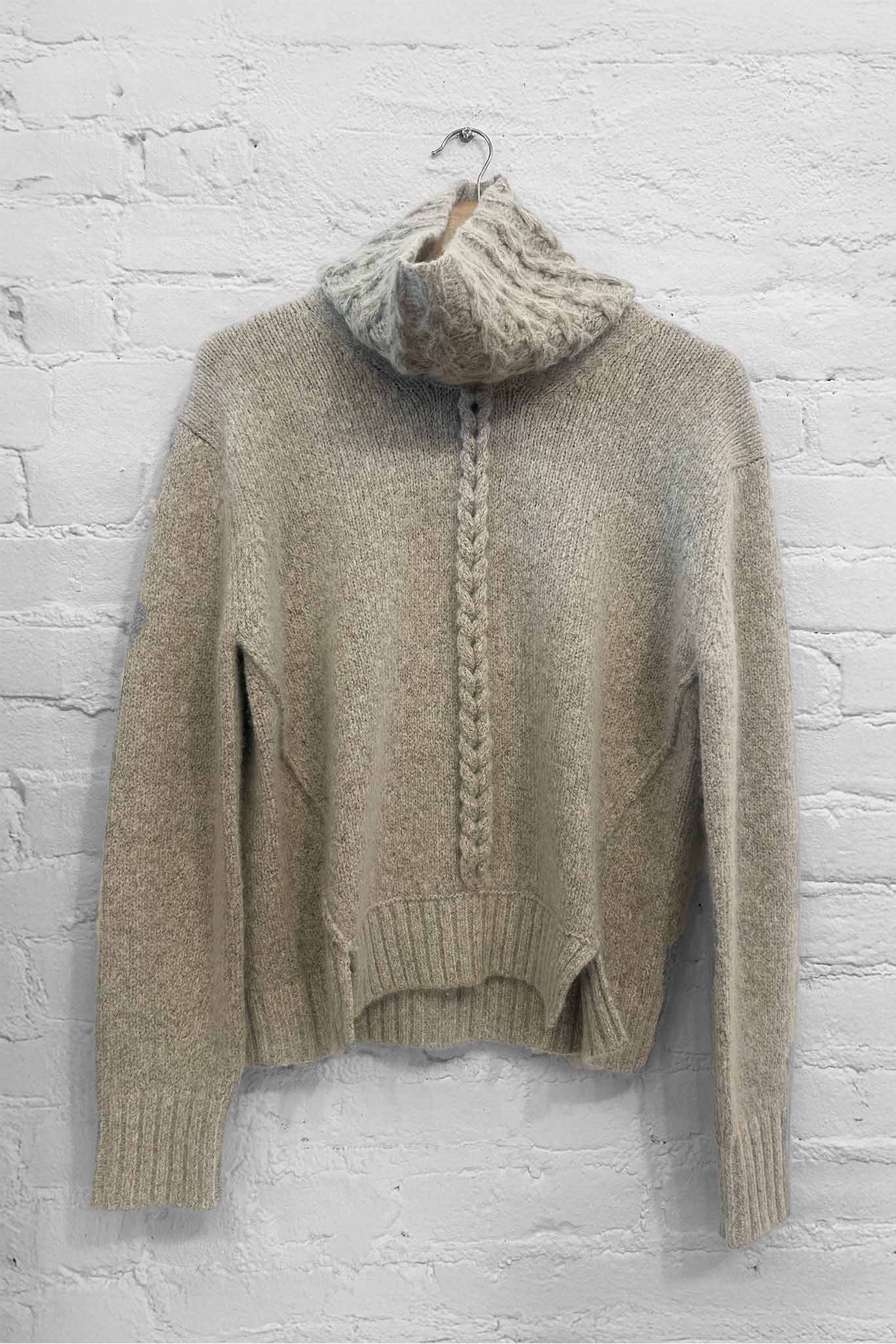 A beige knit long sleeve wool and cashmere sweater paired with a grey knit funnelneck scarf