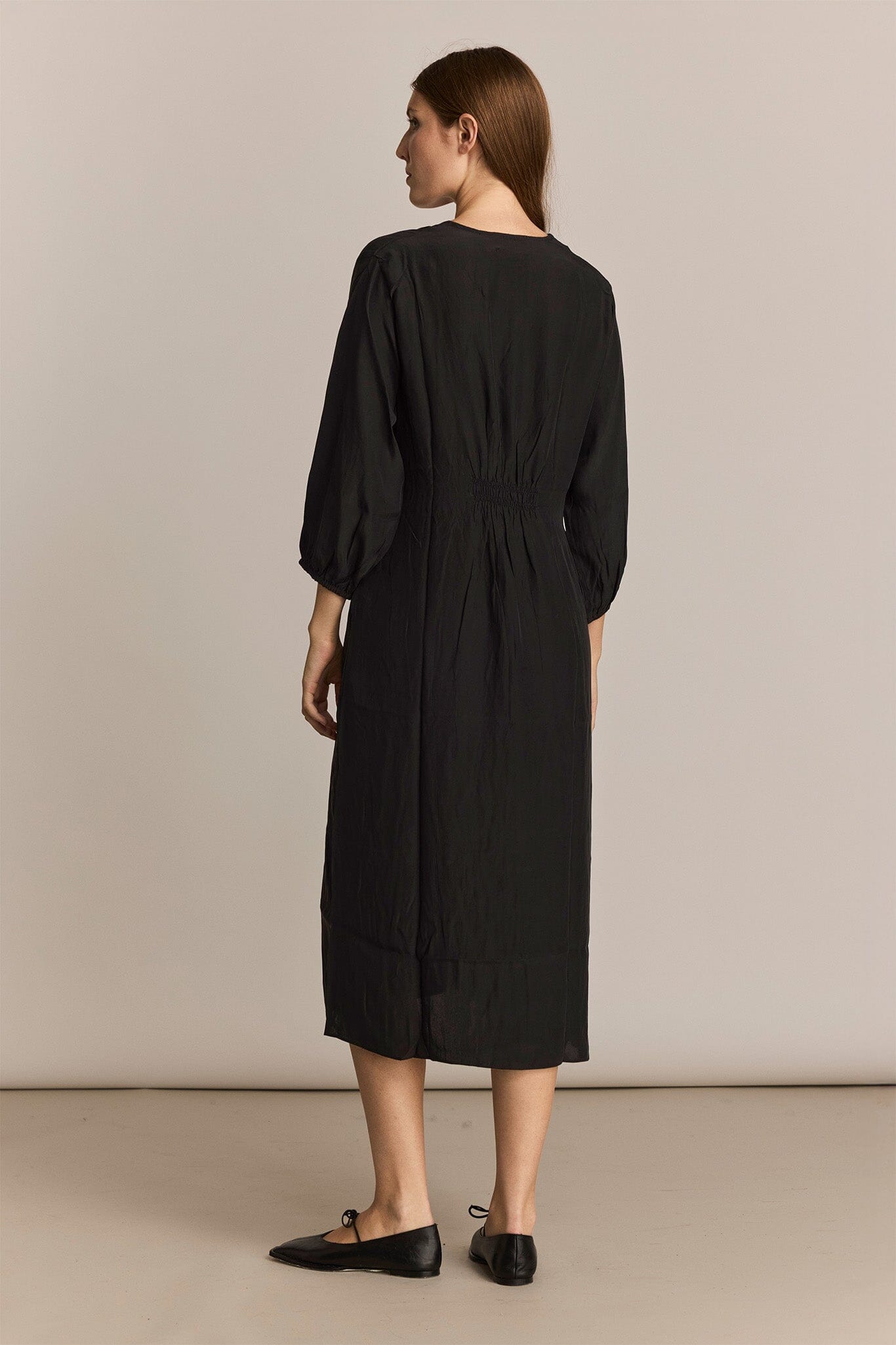 Woman wearing a black dress against a plain background