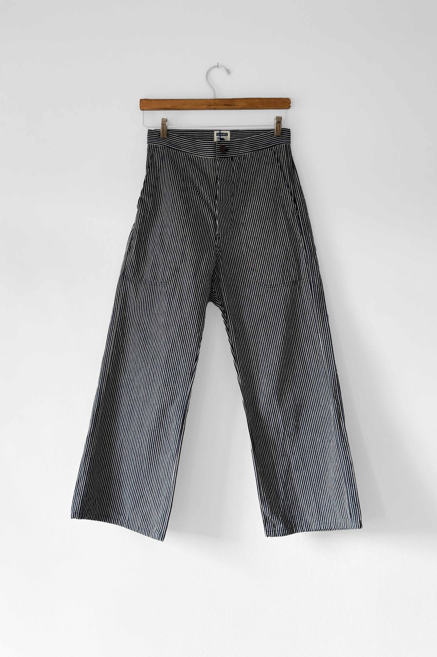 High-rise, wide-leg grey sailor pants with button fly and striped pattern, displayed on a hanger against a white background.