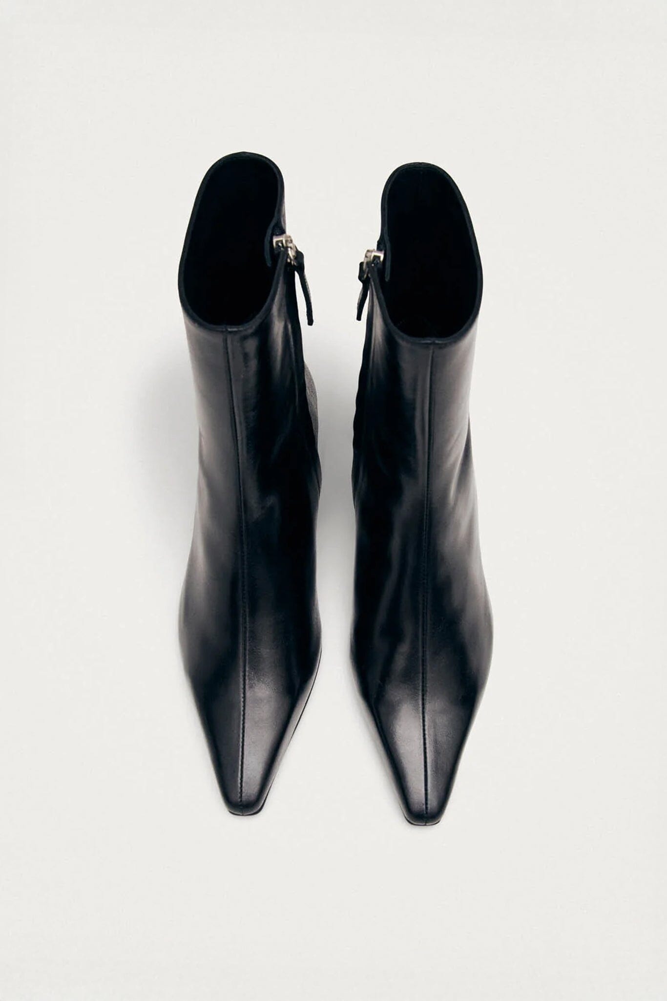 Pair of black pointed-toe boots on a white background