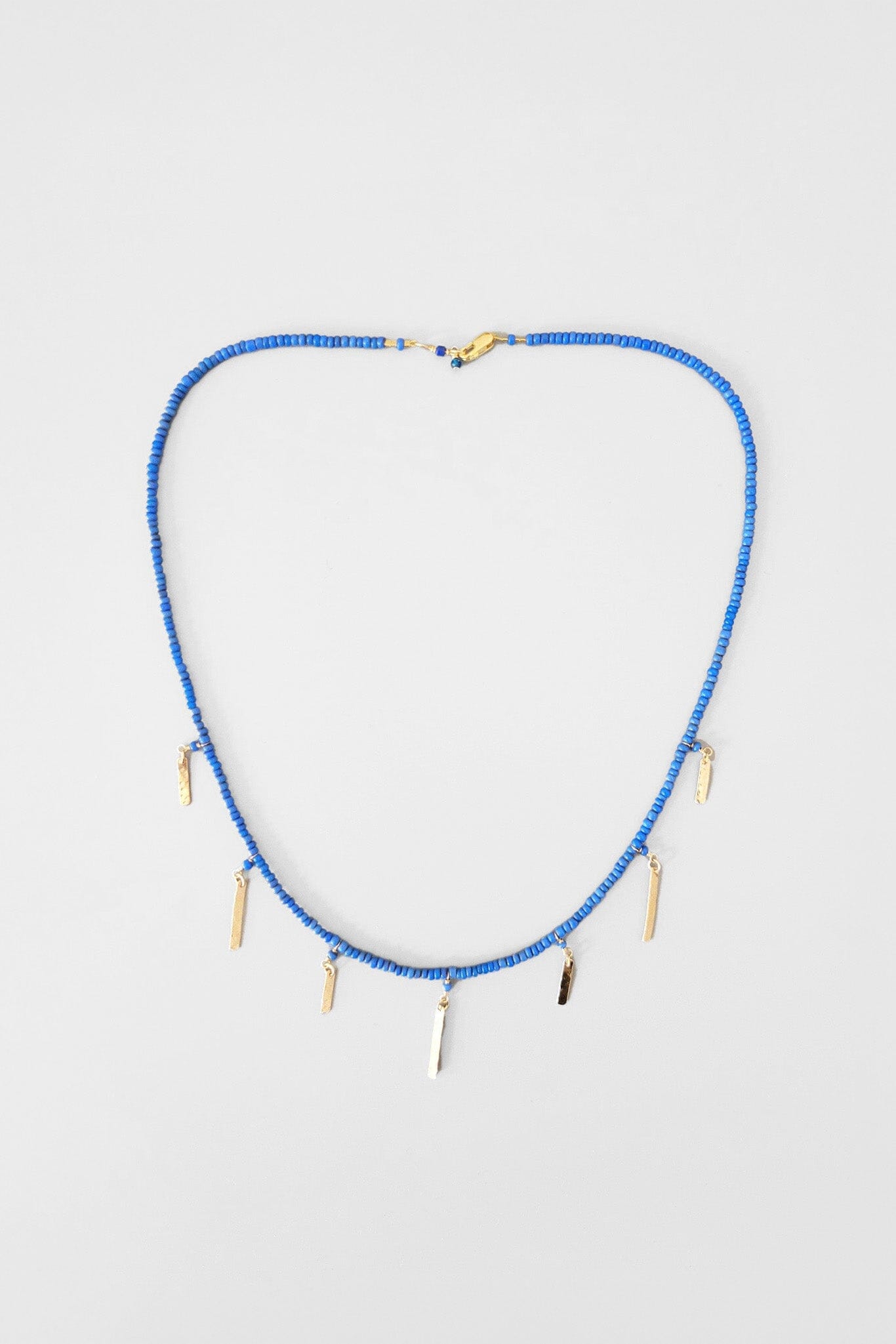 Handmade choker necklace with blue bali beads and 14k gold baguette charms. Handmade in Brooklyn, New York.
