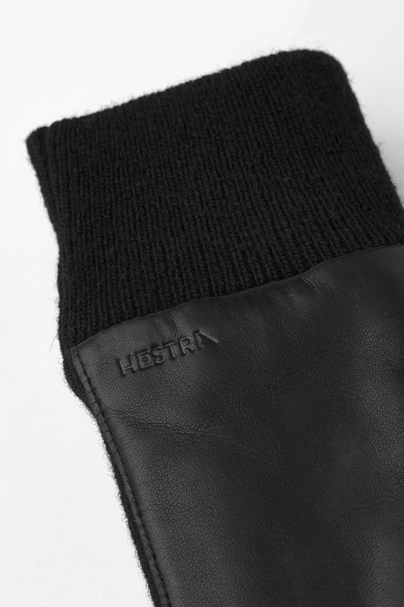 A close up of a black gloves with elastic wrist cuffs and logo