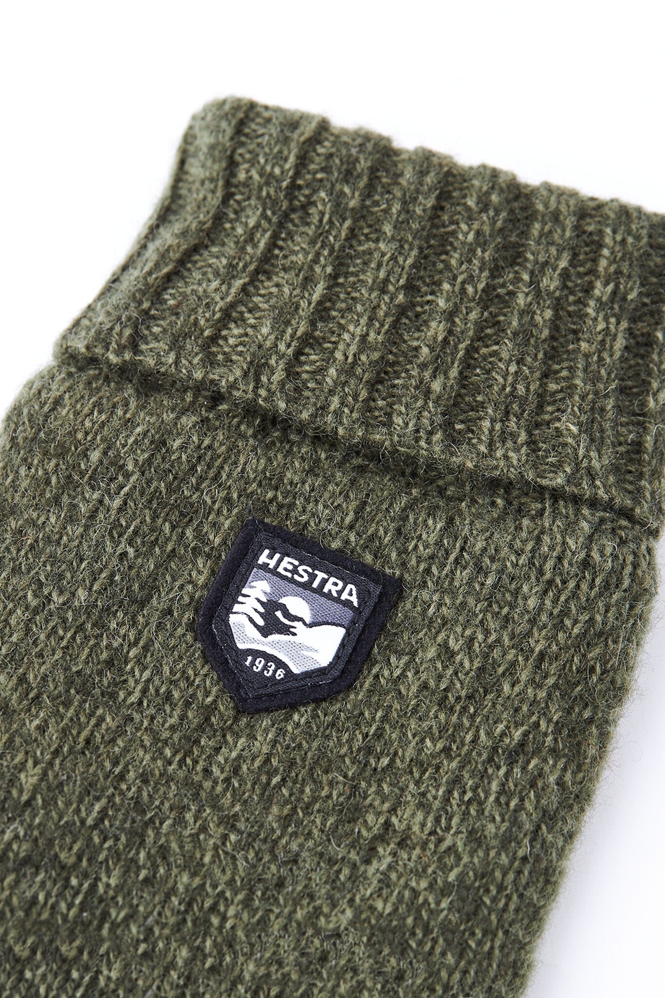 A detailed sho tof the olive green, wool blend gloves with Thinsulate insulation and a small Hestra logo on the backhand.