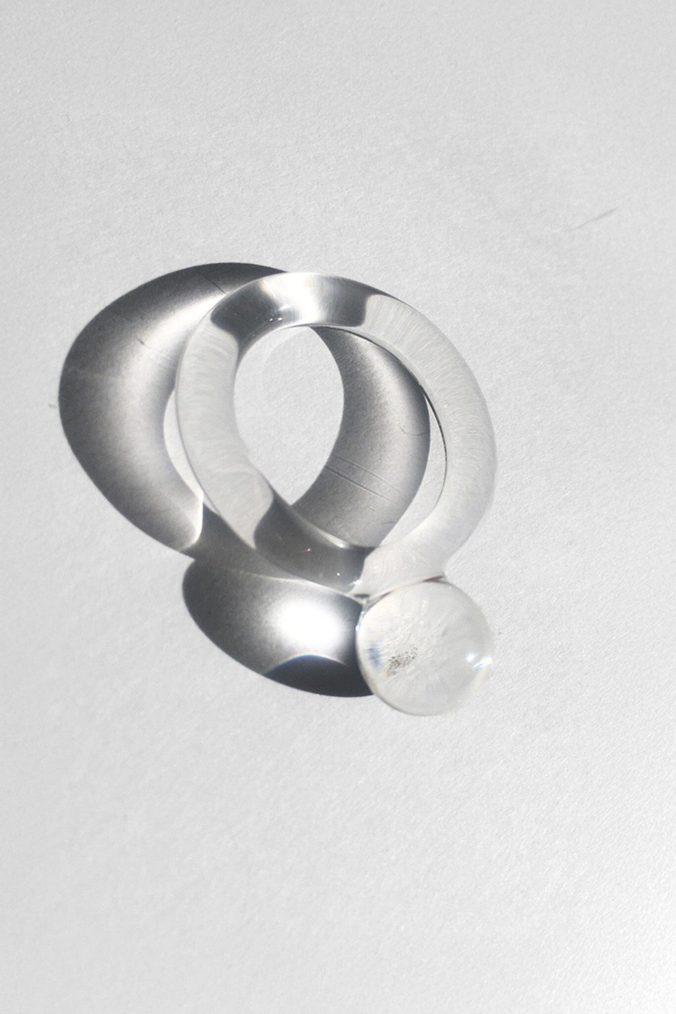 A clear handmade pyrex glass ring with a clear band and a small clear orb ball.