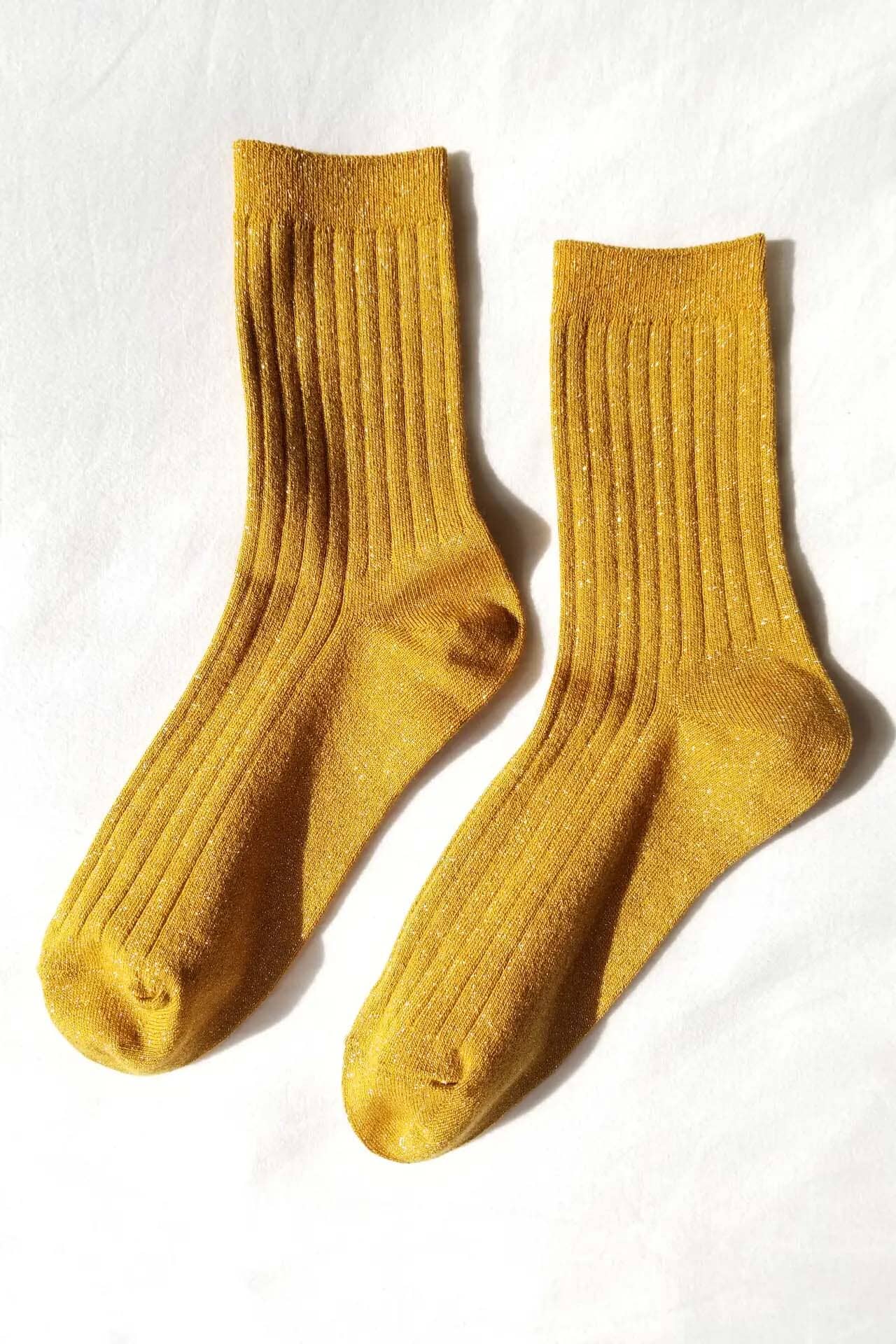 Pair of ribbed mustard yellow socks on a white background