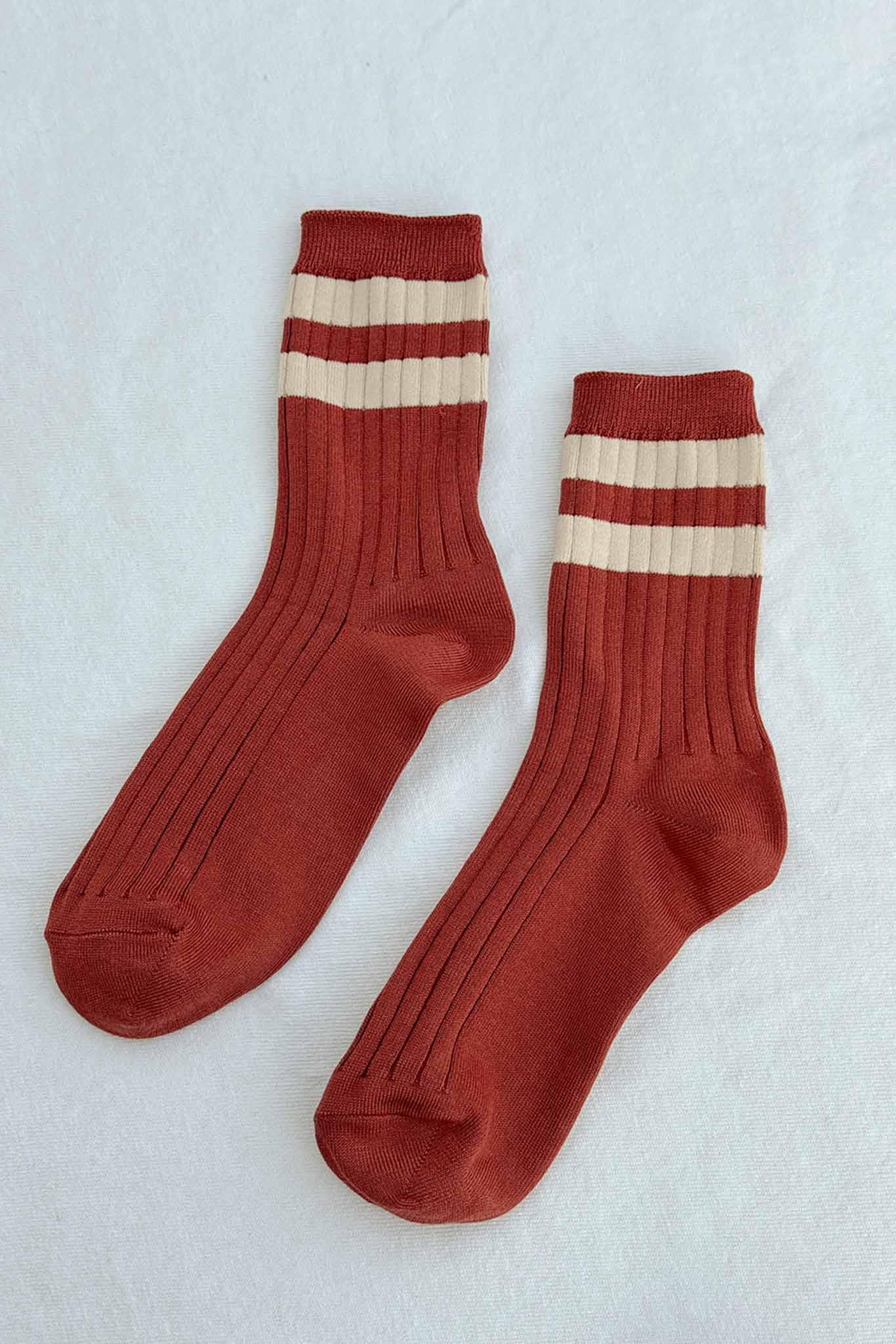 A flat view of a pair of red and cream striped crew socks
