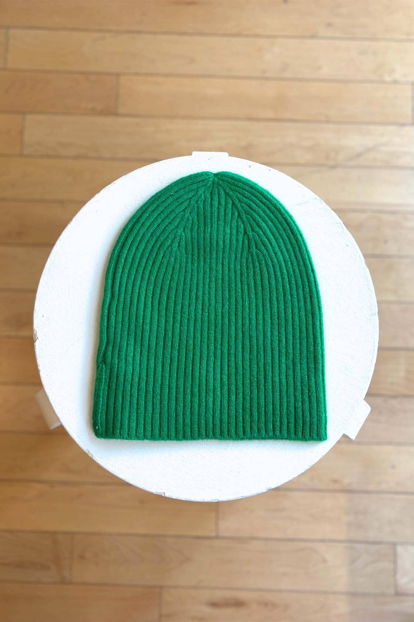 Green beanie with a wooden background
