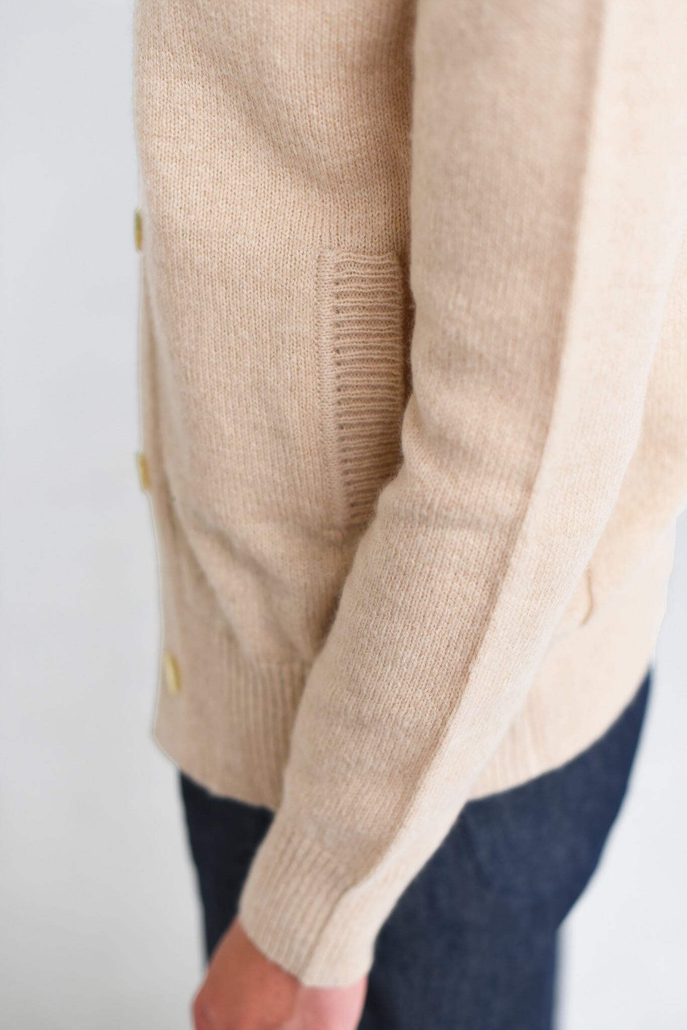 A close up shot of a beige long sleeve cashmere sweater