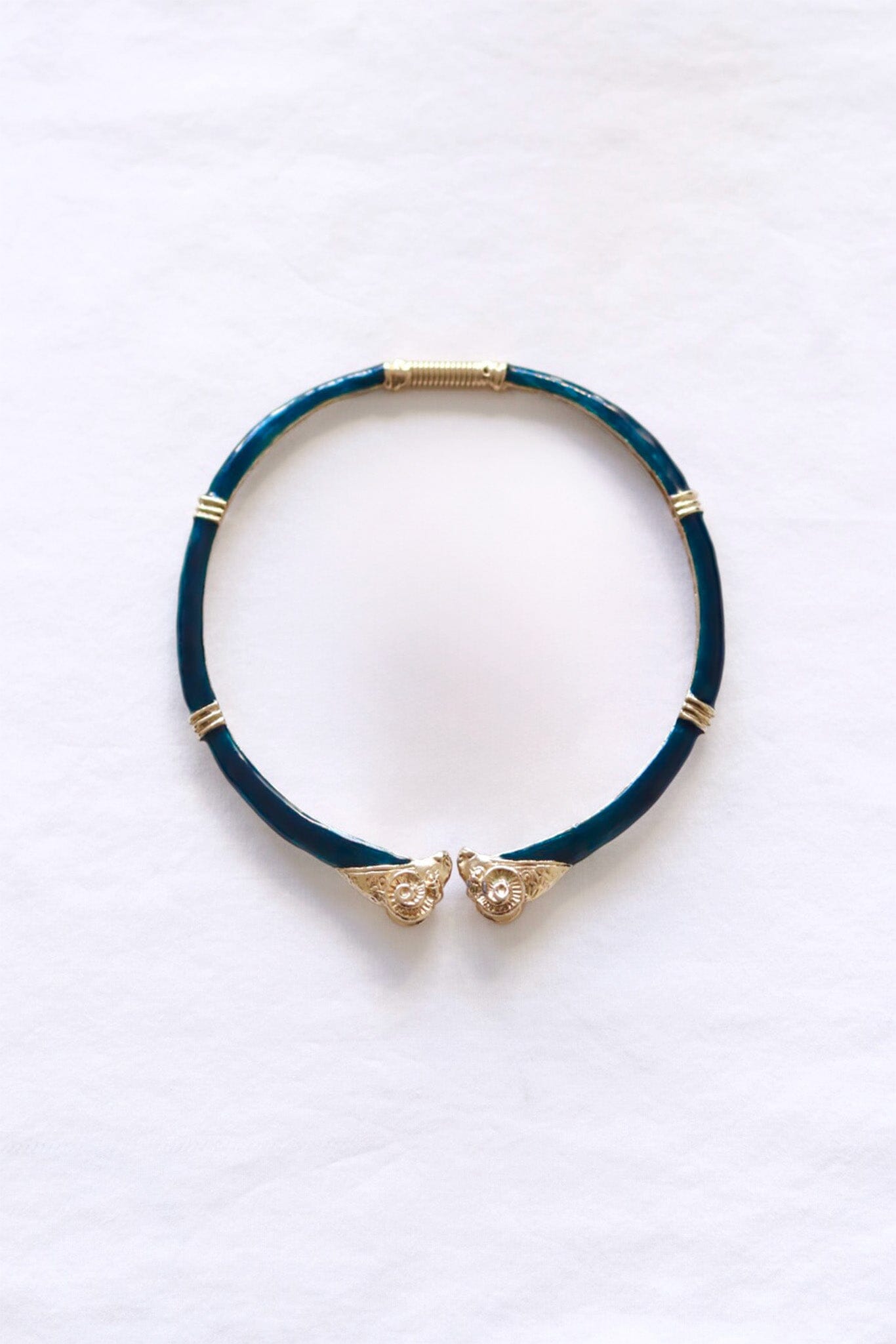 Dark green choker necklace with gold accents on a white background