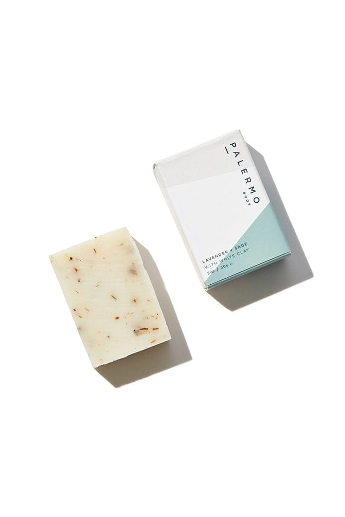 A bar of soap with a white clay texture and a packaged box with a white and blue design. The box has the brand 'Palermo Body' printed on it.