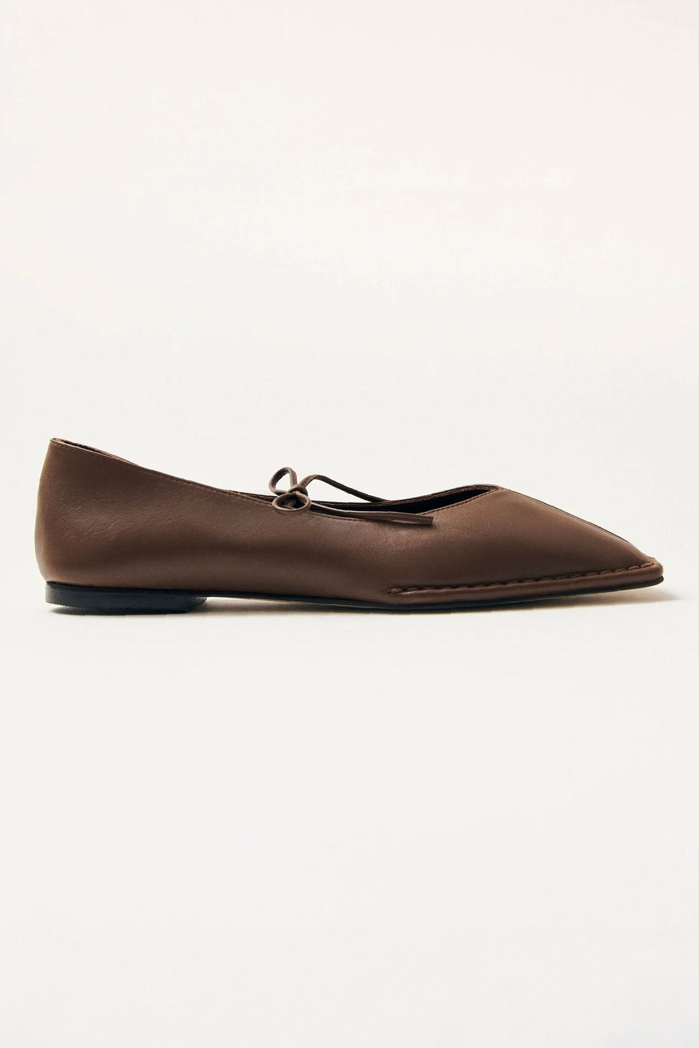 Brown flat shoe with a top tie on a white background