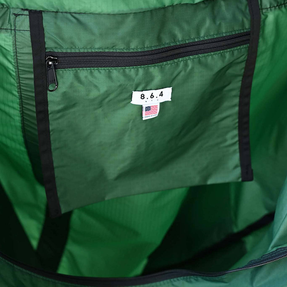
                  
                    Close-up of a green 8.6.4. bag with an interior zipper pocket
                  
                