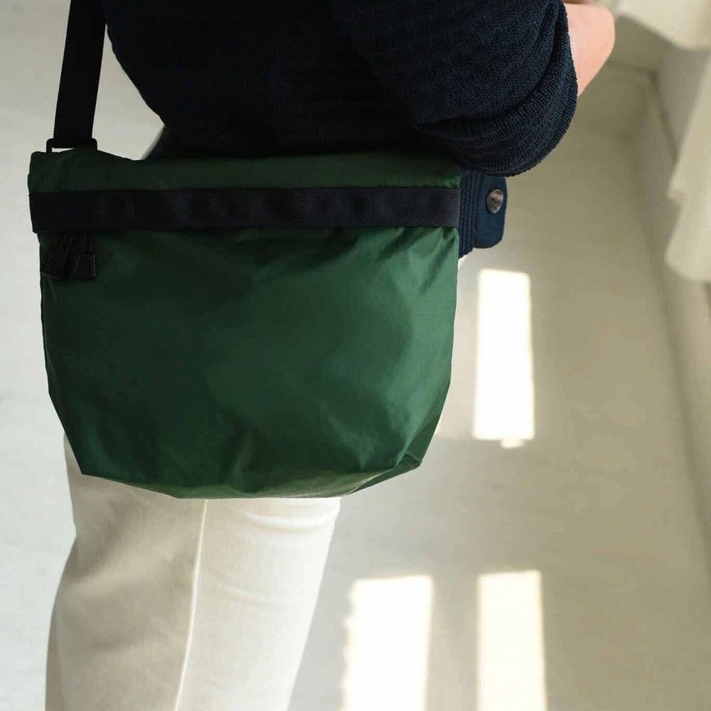 A close up shot of a forest green square nylon bag