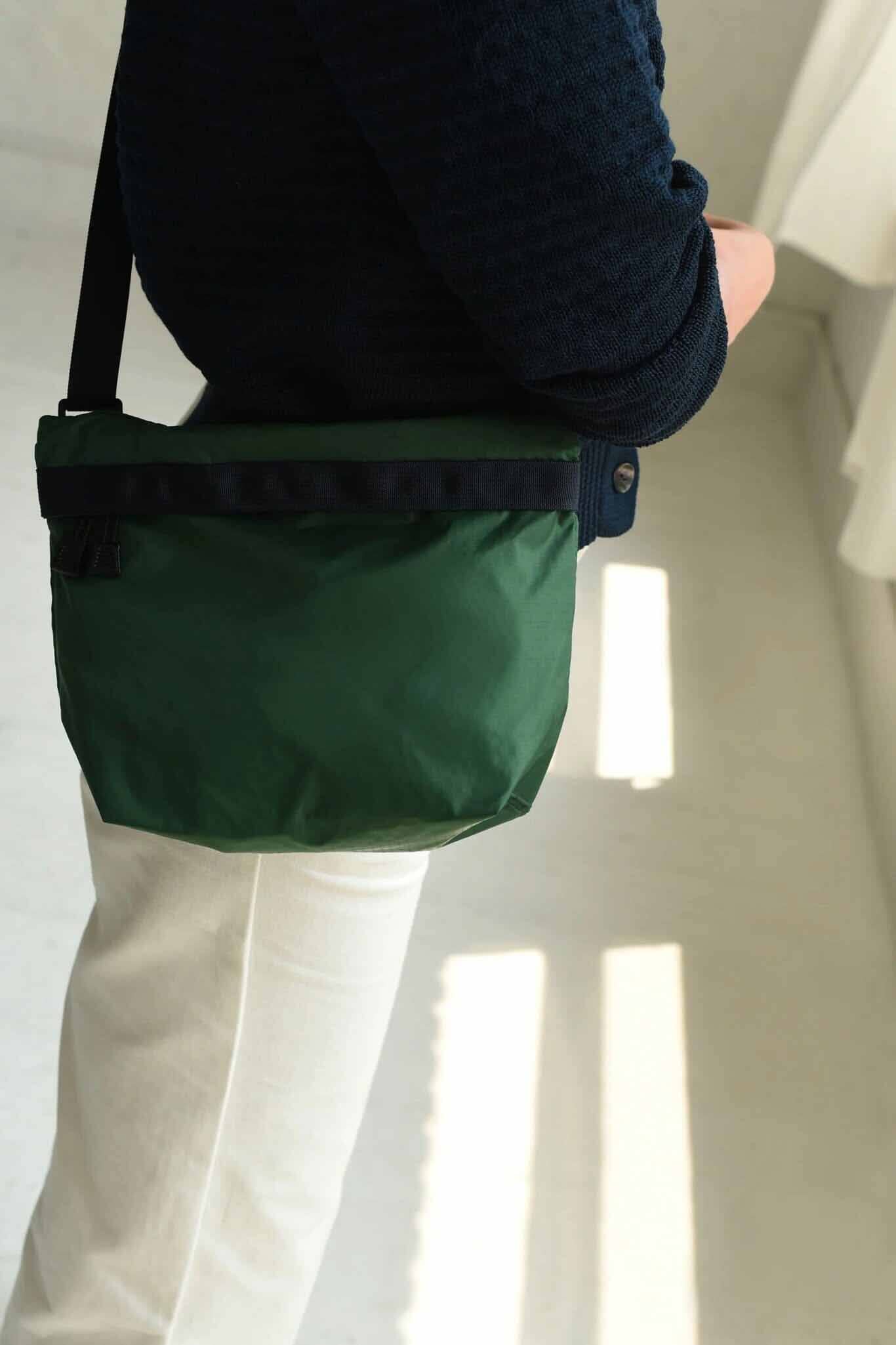A close up shot of a forest green square nylon bag