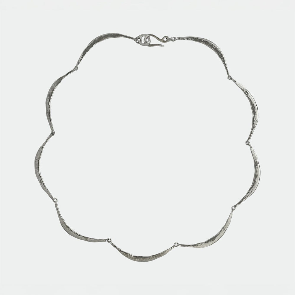 Modern silver necklace on a light gray background