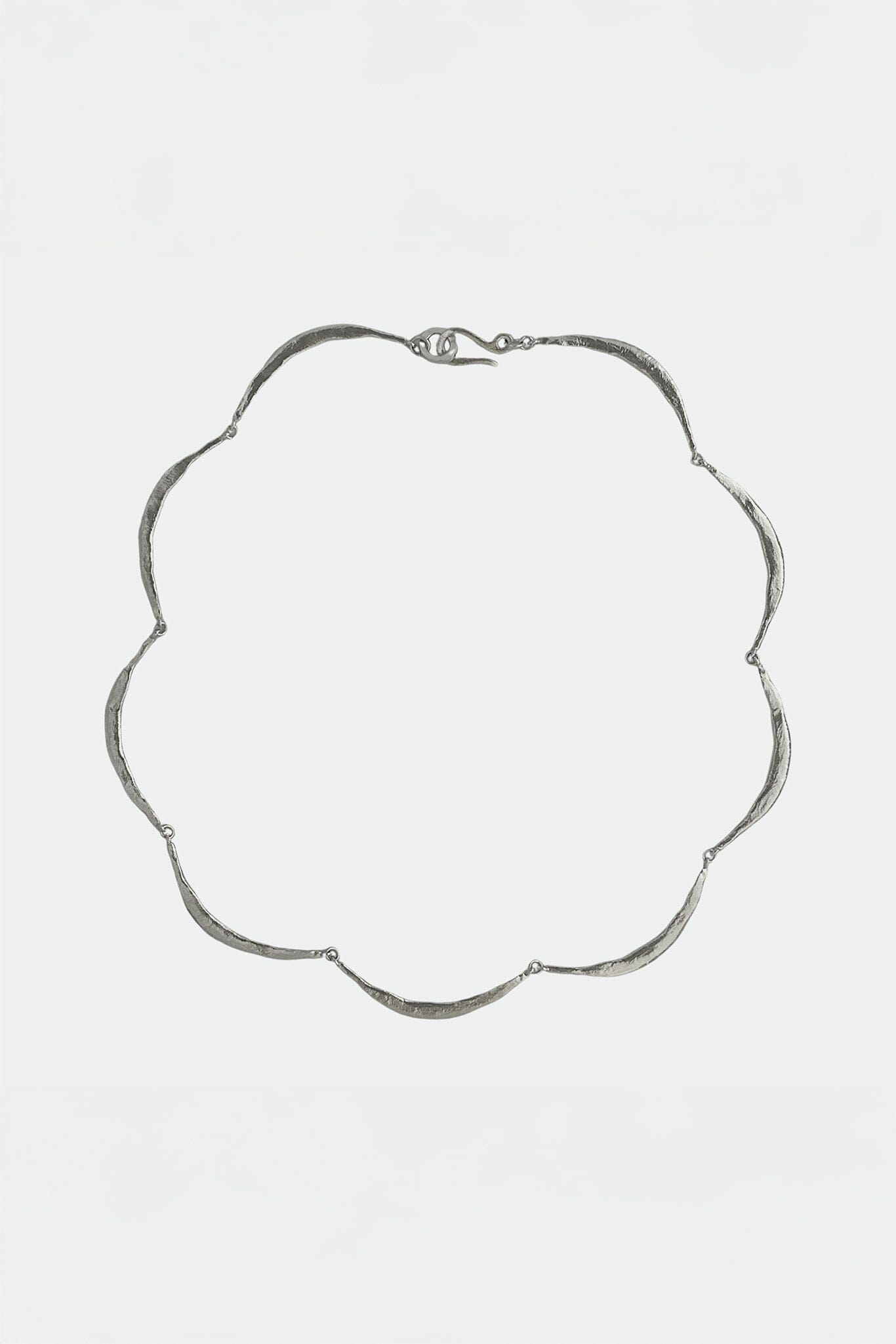 Modern silver necklace on a light gray background