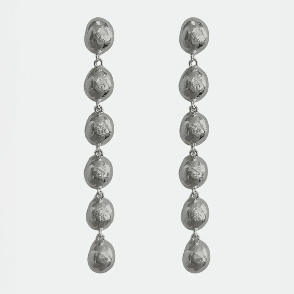 Pair of silver drop earrings on a light gray background