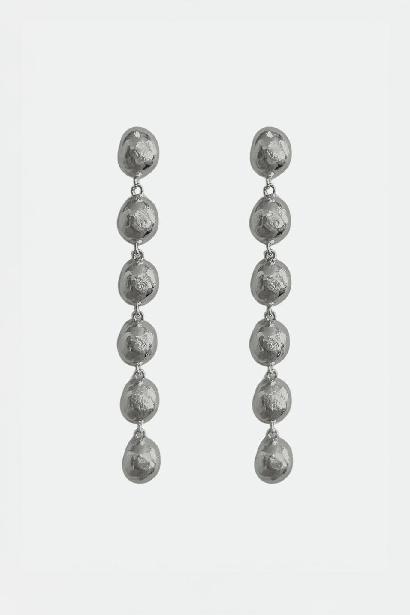 Pair of silver drop earrings on a light gray background