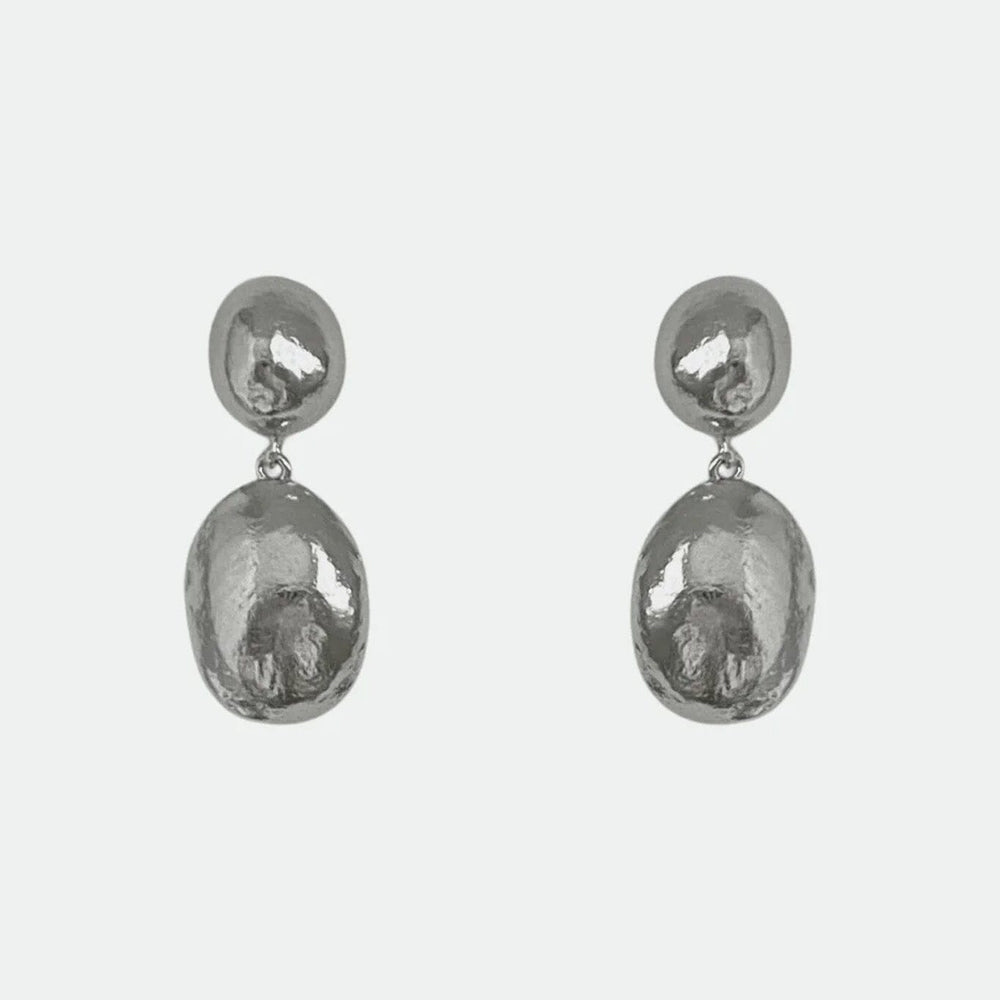 Pair of silver dome stud drop earrings on a light gray background