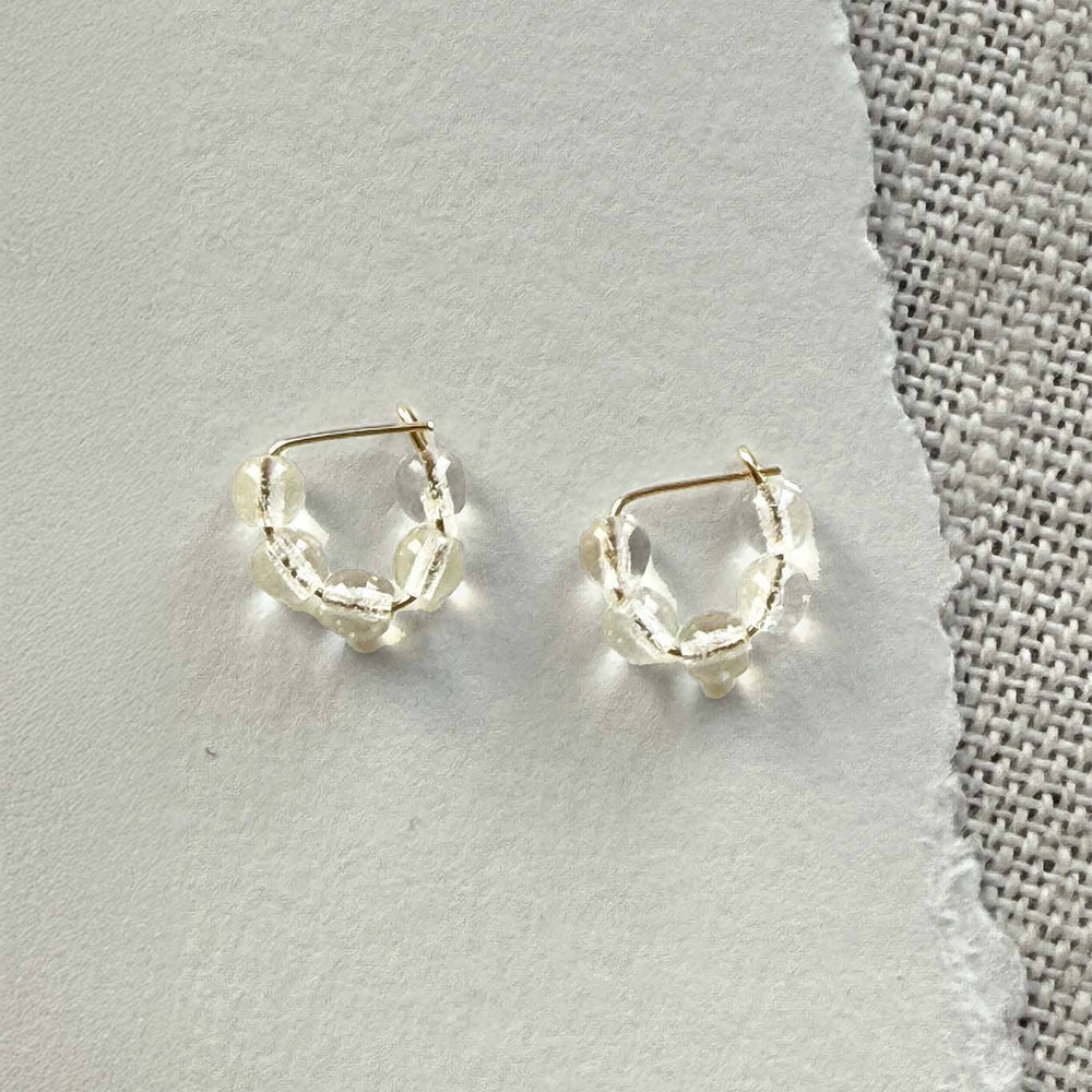 Pair of gold hoop earrings on a gray surface