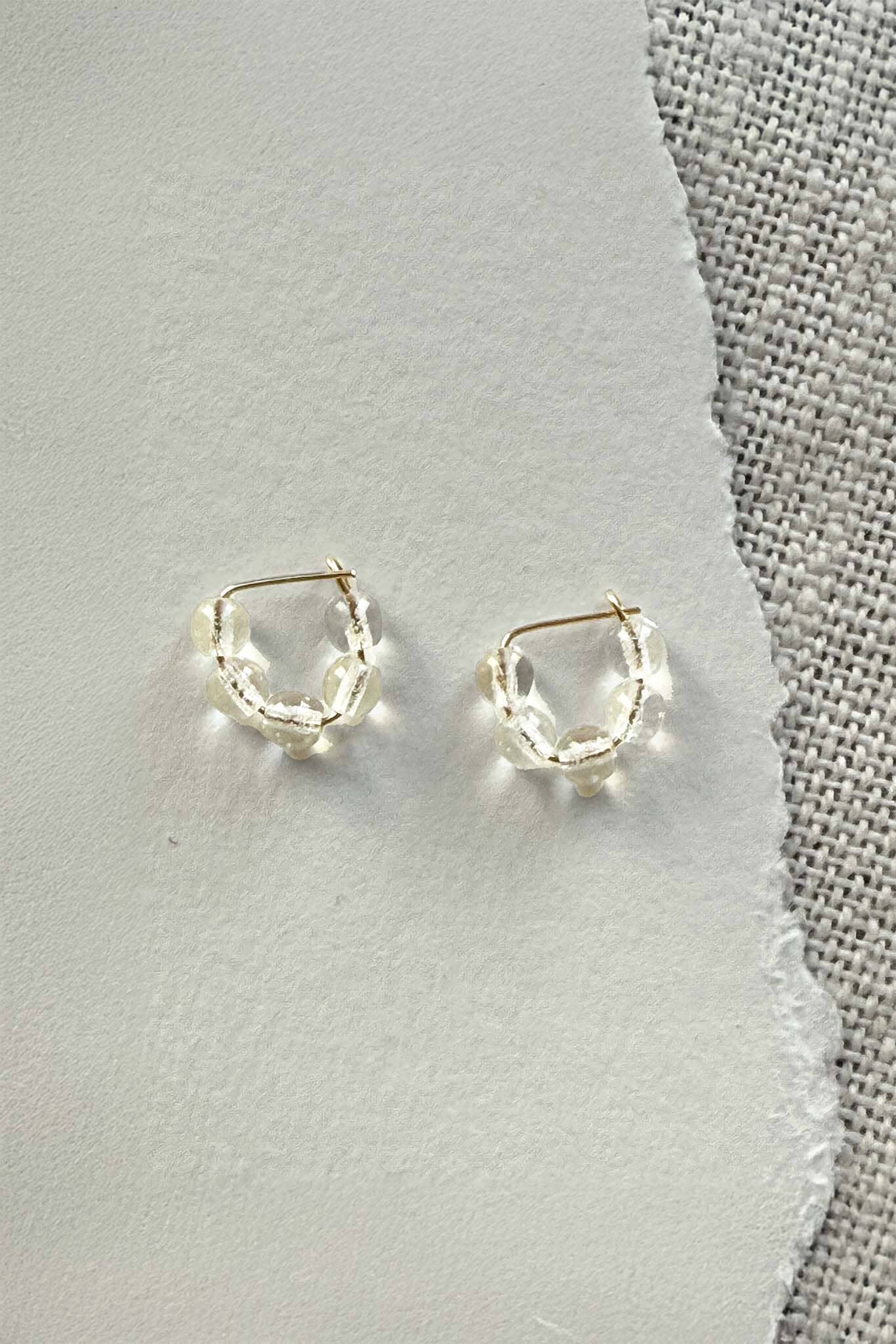 Pair of gold hoop earrings on a gray surface