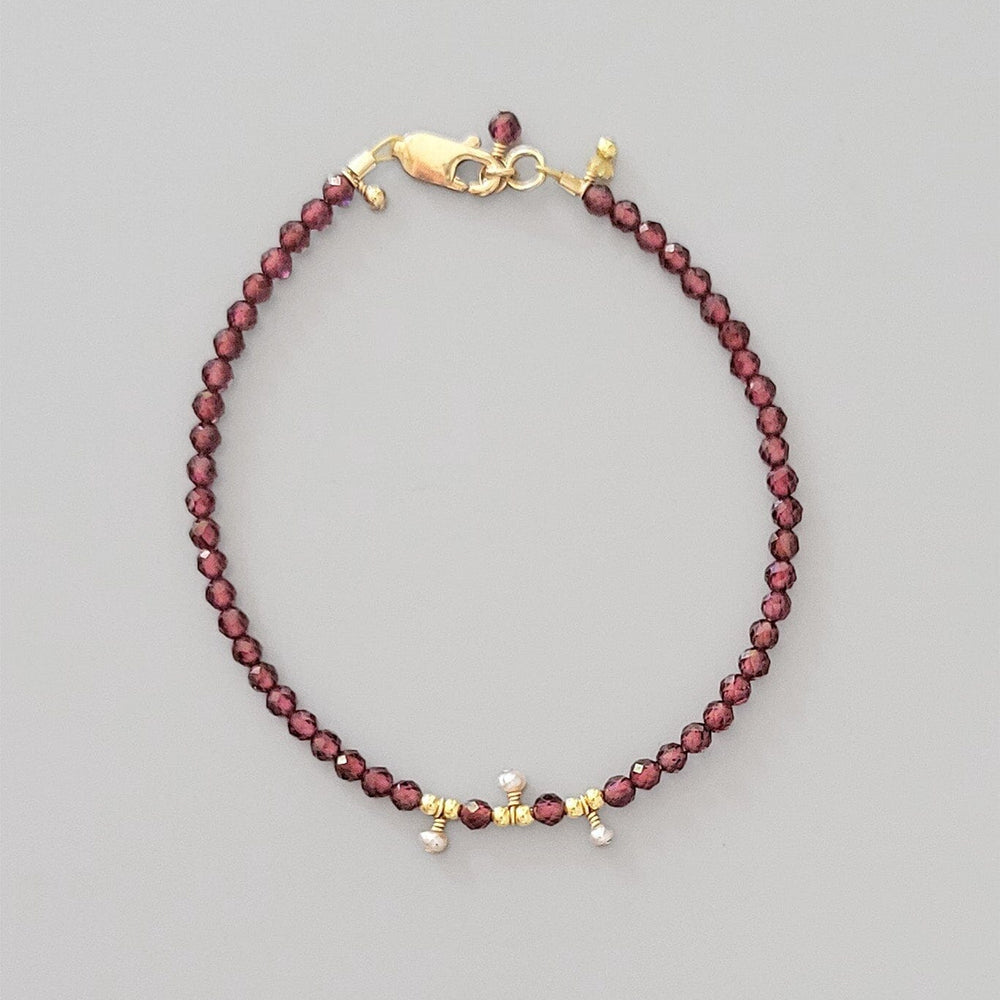 Beaded bracelet with gold clasp on a gray background