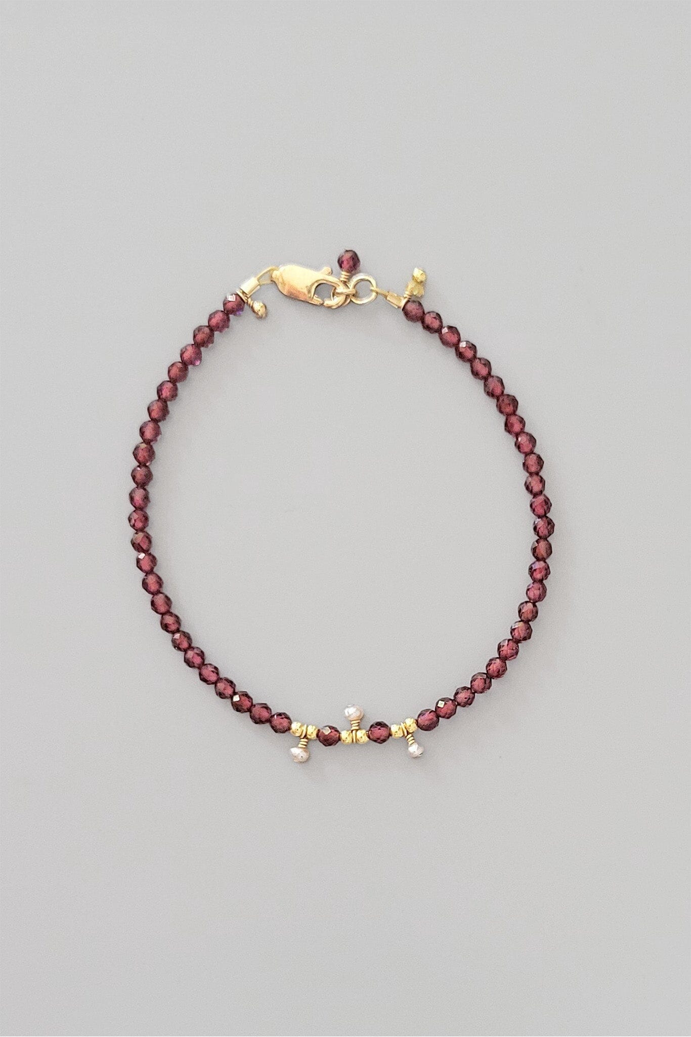 Beaded bracelet with gold clasp on a gray background