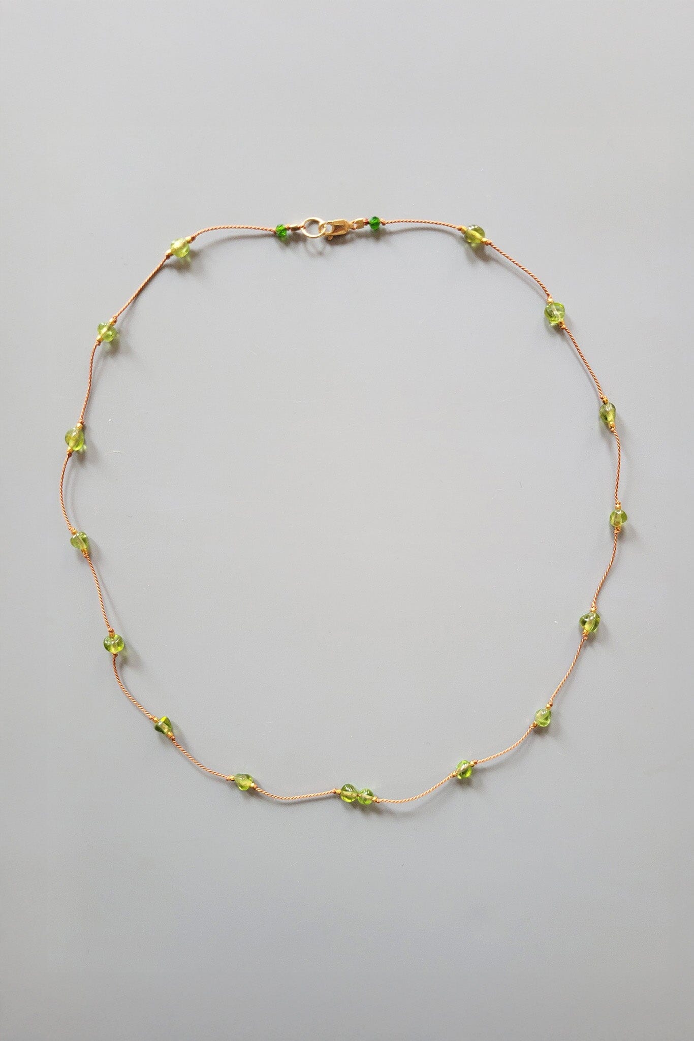 Necklace with green beads on a gray background