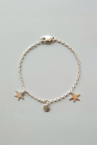 Silver bracelet with star charms on a light gray background
