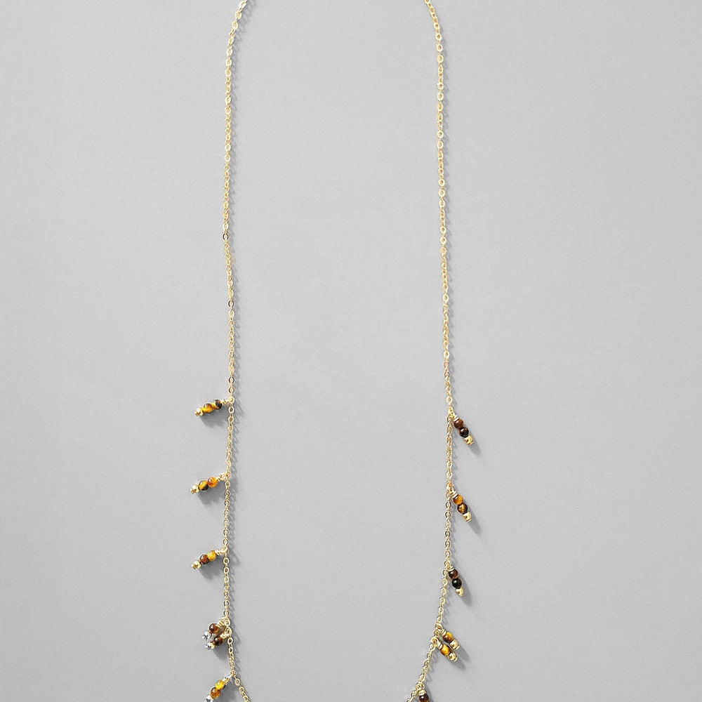 Necklace with small tigers eye beads on a gray background