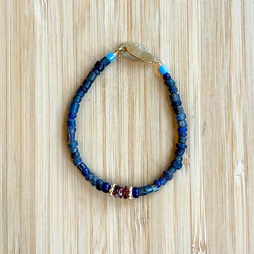 Beaded bracelet with blue and multicolor beads on a wooden surface