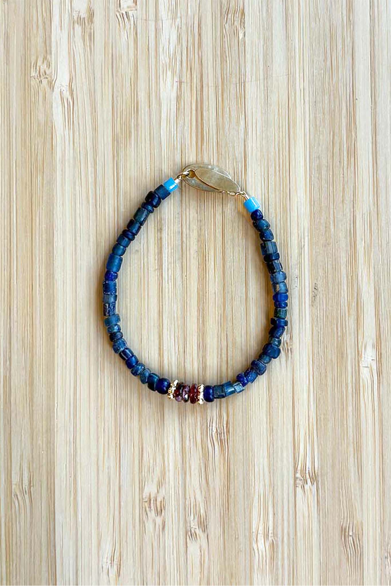 Beaded bracelet with blue and multicolor beads on a wooden surface