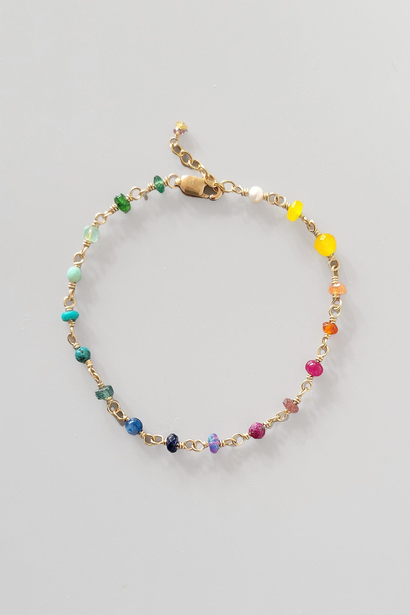 Multicolored beaded rainbow bracelet on a light gray background