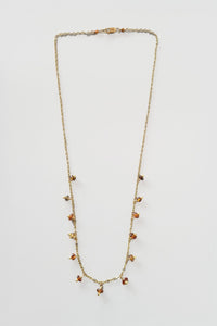 Necklace with small hessonite beads on a light gray background