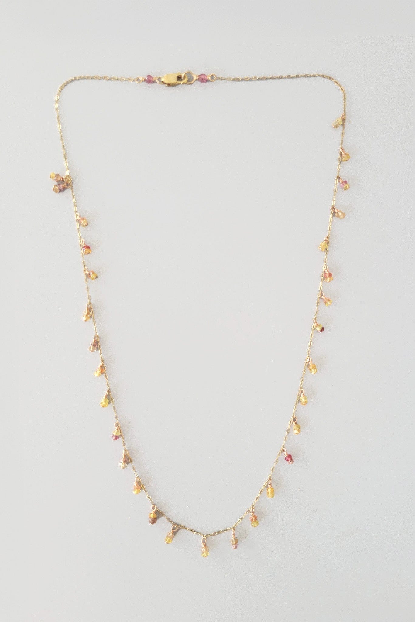 Necklace with small yellow beads on a light gray background