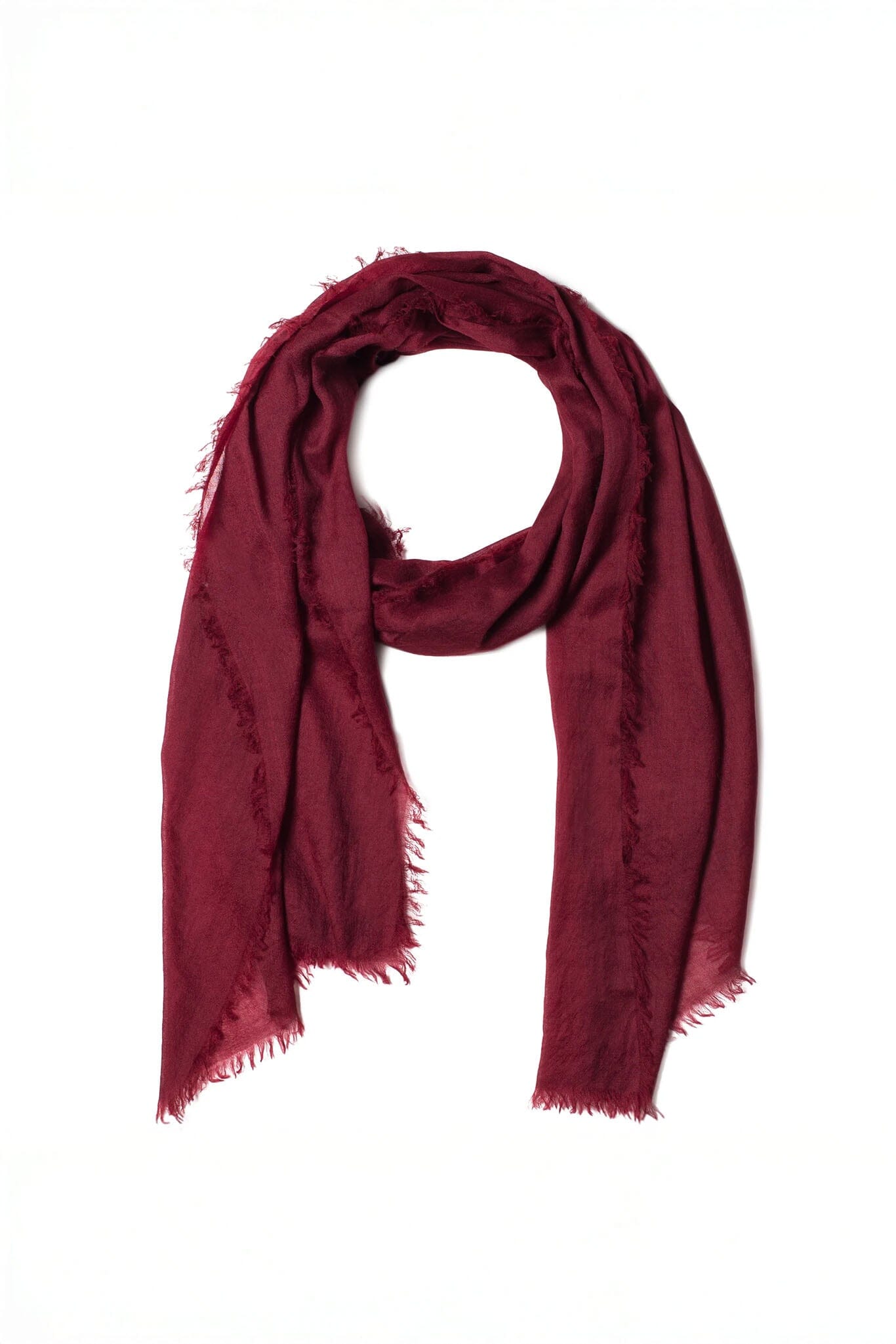 Red cashmere and merino scarf with frayed edges on a white background