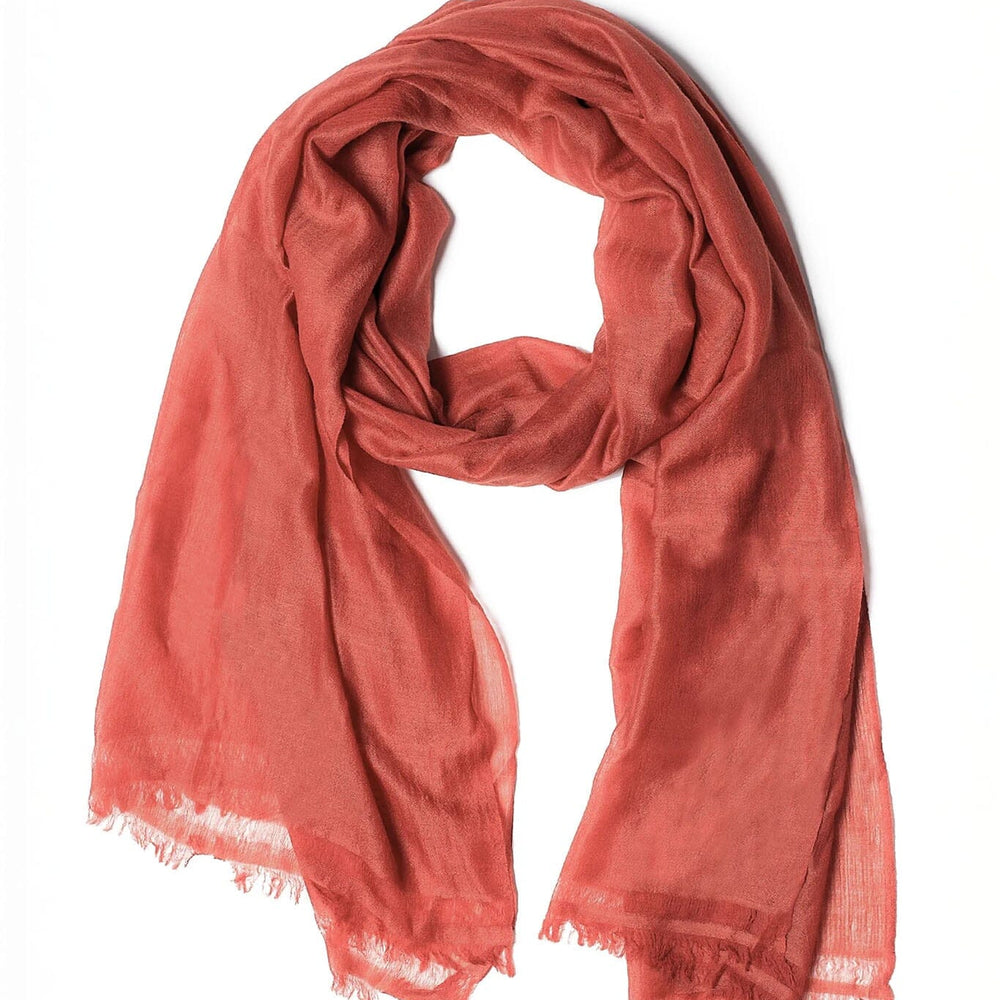 Red merino wool scarf with frayed edges on a white background