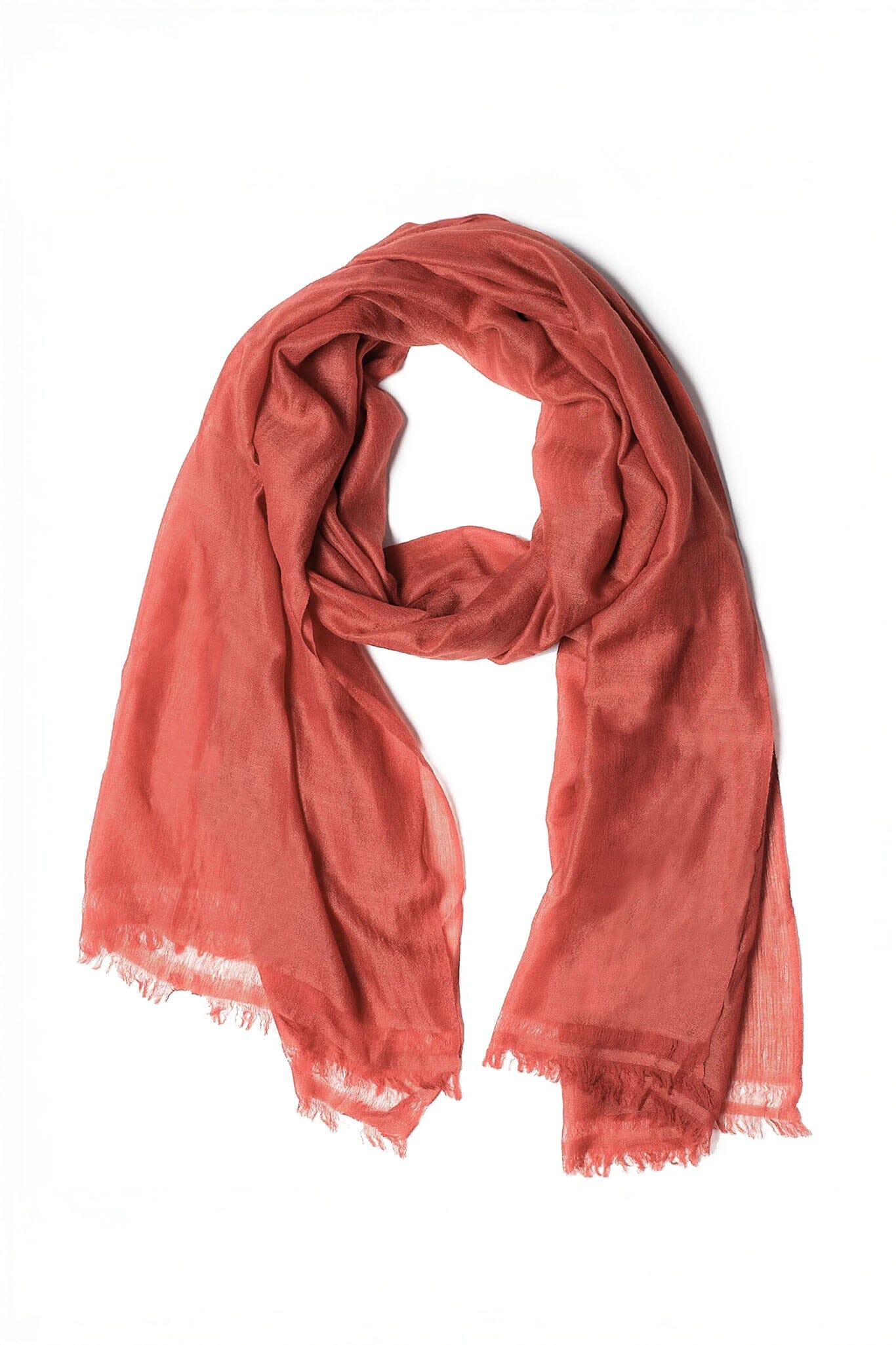 Red merino wool scarf with frayed edges on a white background