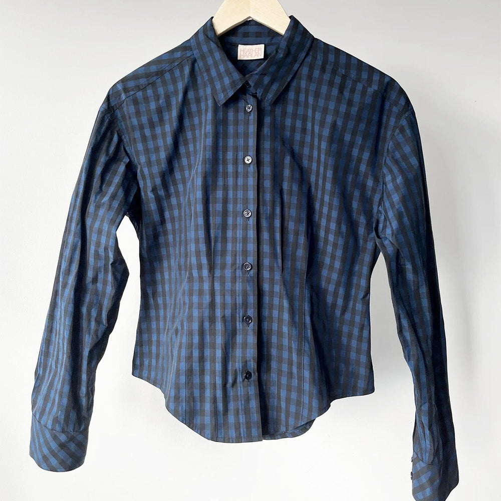 
                  
                    Blue checkered shirt on a hanger against a white background
                  
                