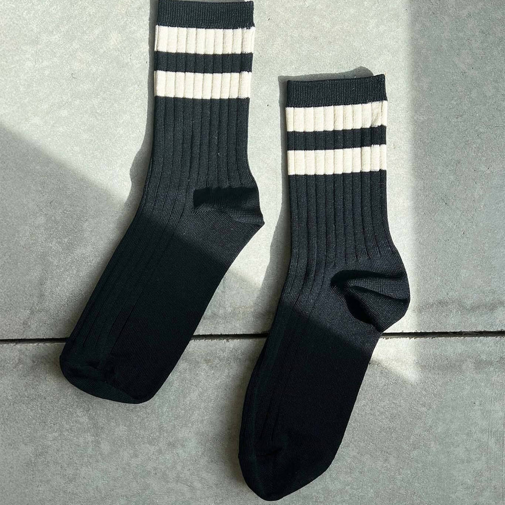 Black socks with white stripes on a gray surface